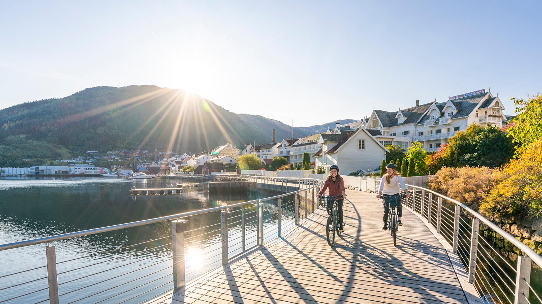 Planlegg reisen til Sognefjorden: To personer sykler langs Fjordstien i Sogndal ved Sognefjorden på Vestlandet