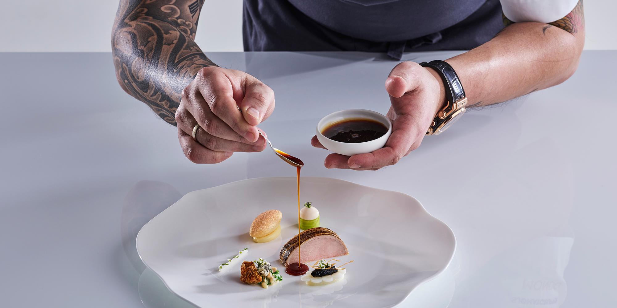 Den norske kokken Christian André Pettersen legger opp mat på en tallerken i Bocuse d’Or 2019
