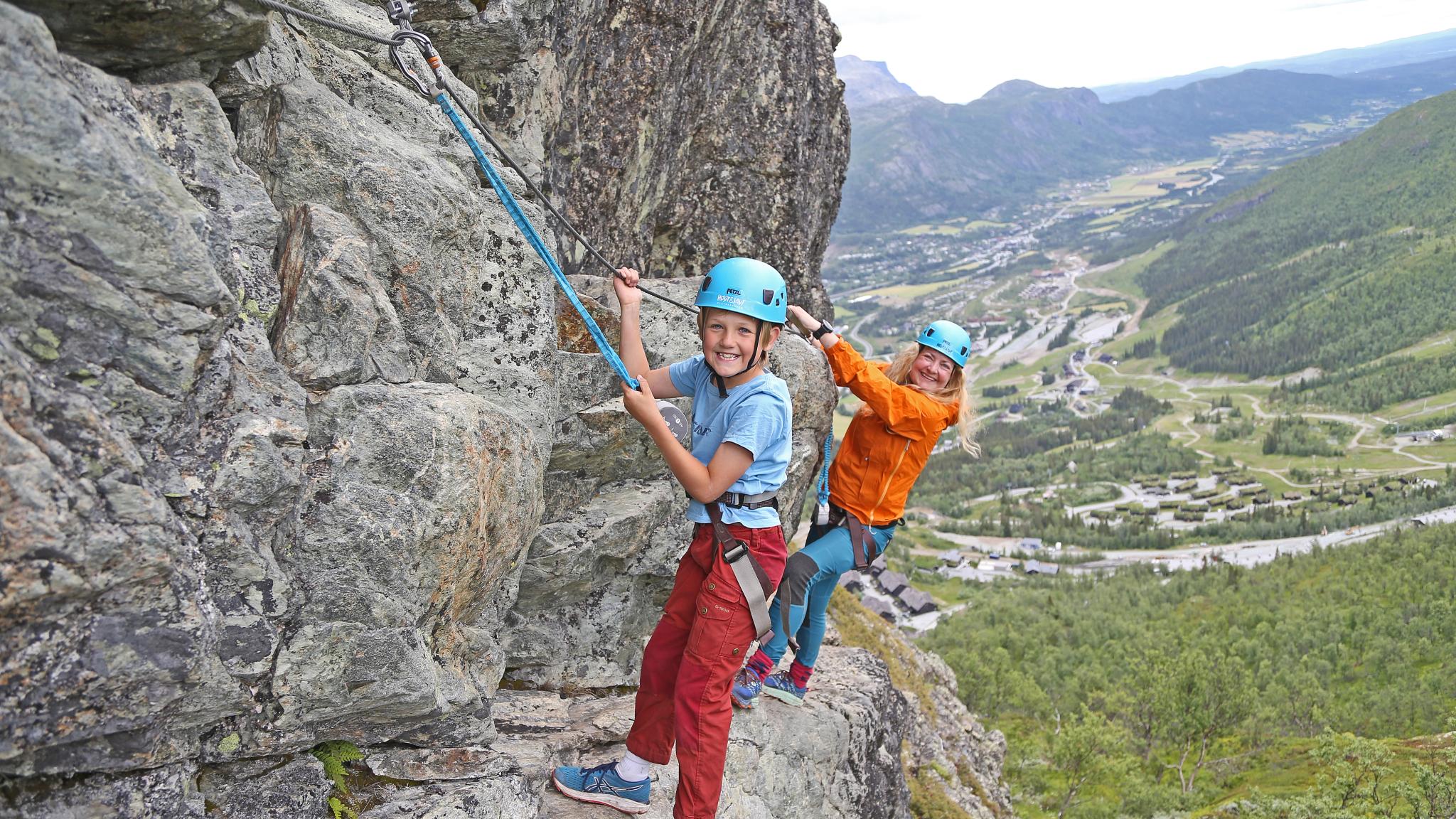 Moeder en zoon aan het klimmen in het via ferrata in Hemsedal, Hallingdal, Oost-Noorwegen