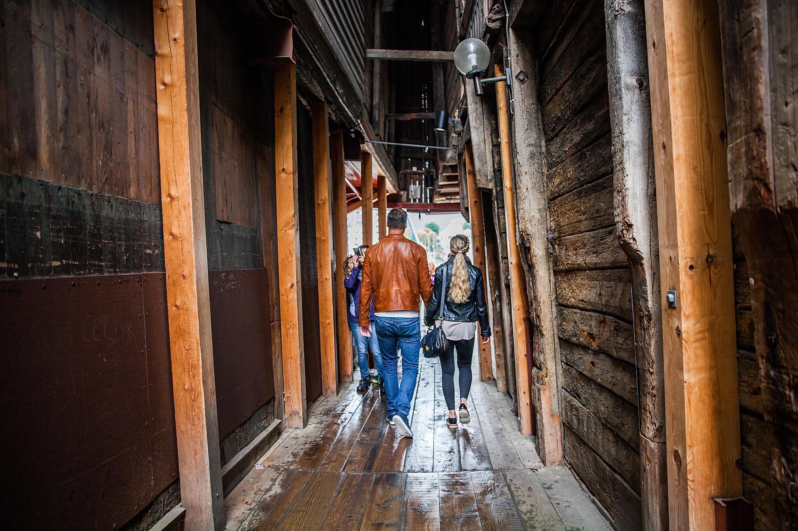Et par som går gjennom Bryggen i Bergen
