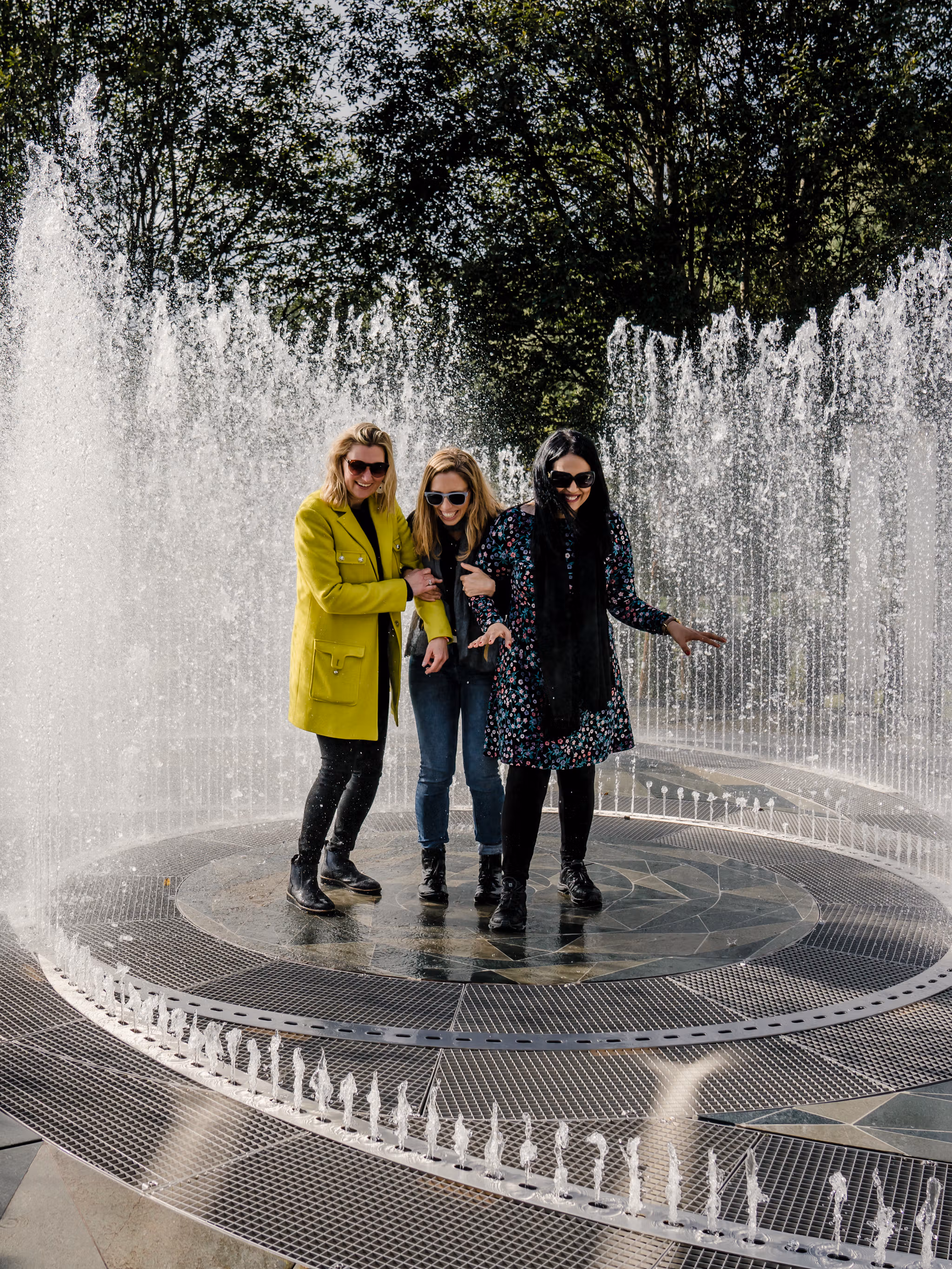 Vier Frauen stehen im Brunnen, umrundet von Spiegeln im Kistefoss Museum in Norwegen