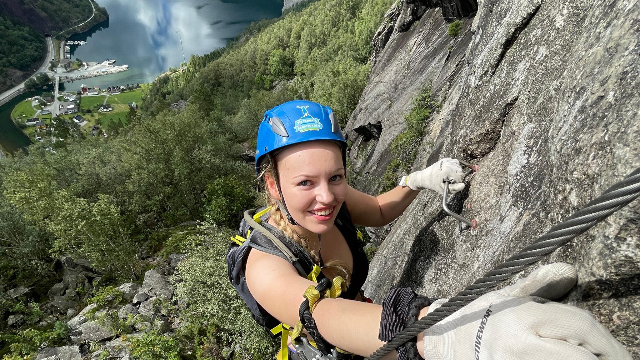 Woman climbing via ferrata in Kyrkjeveggen