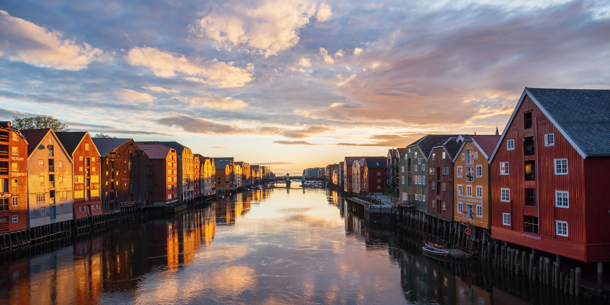 Solnedgang over de gamle trehusene langs Nidelva, som renner tvers gjennom Trondheim i Trøndelag