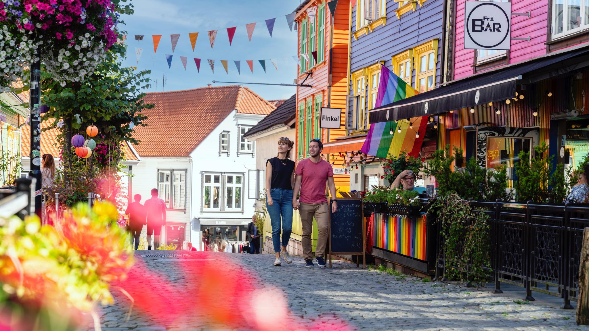 A man and a woman walking down Fargegaten, The Colorful Street, in Stavanger