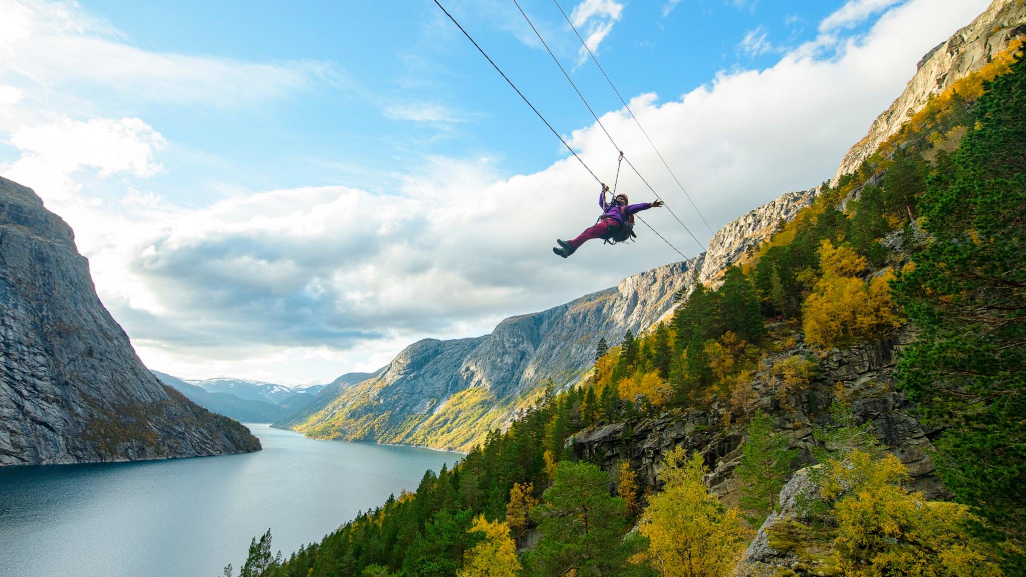 Woman sliding down a zipline near Trolltunga in Fjord Norway