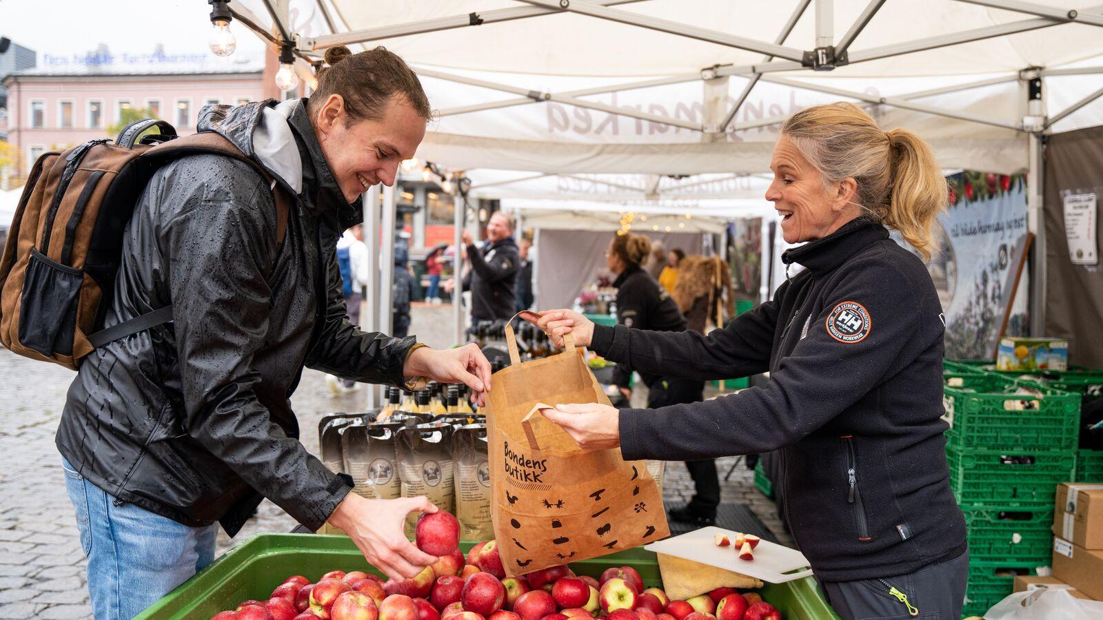 En mann kjøper epler på Matstreif matfestival i Oslo