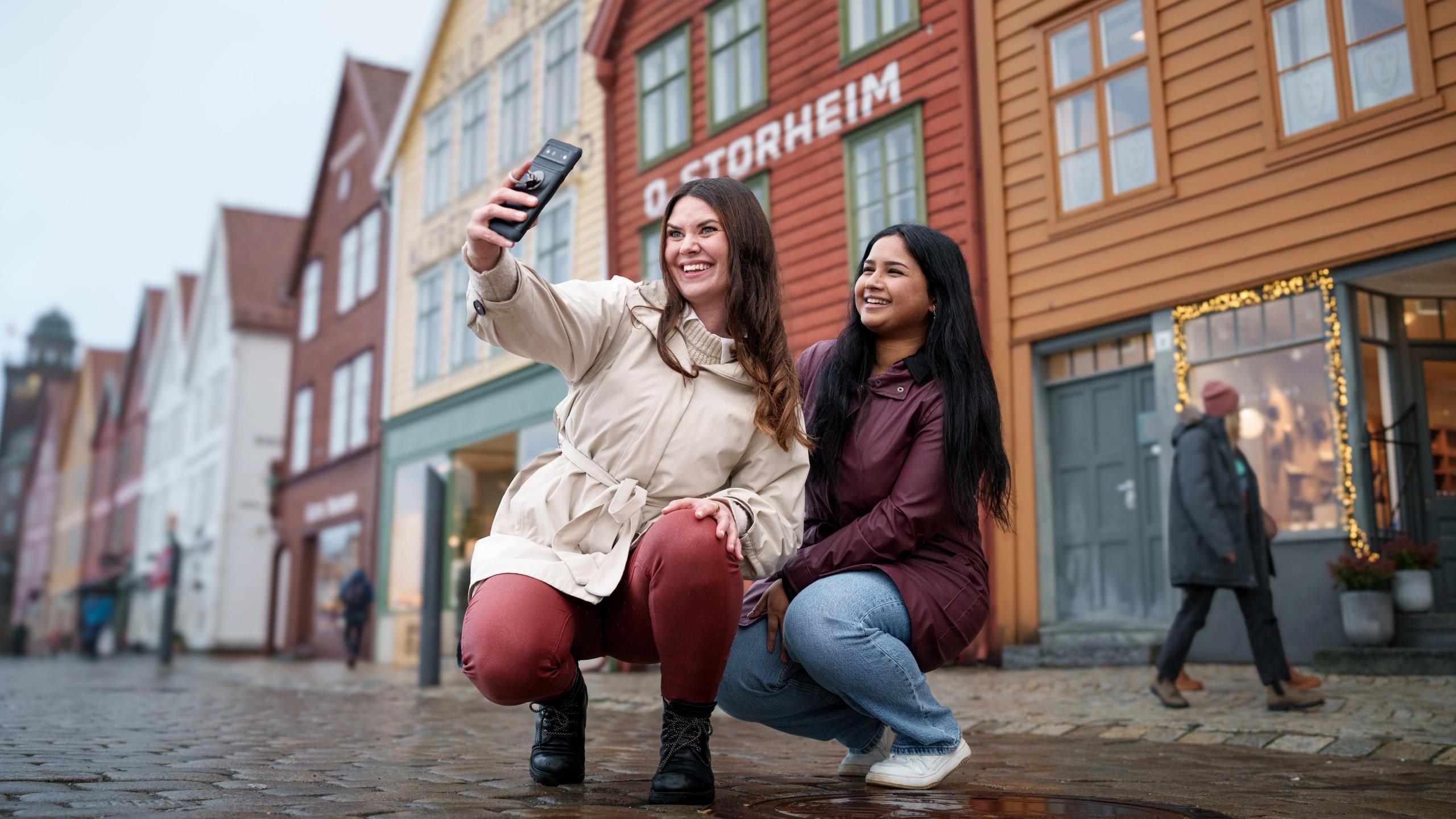 To damer tar en selfie på Bryggen i Bergen, Vestlandet