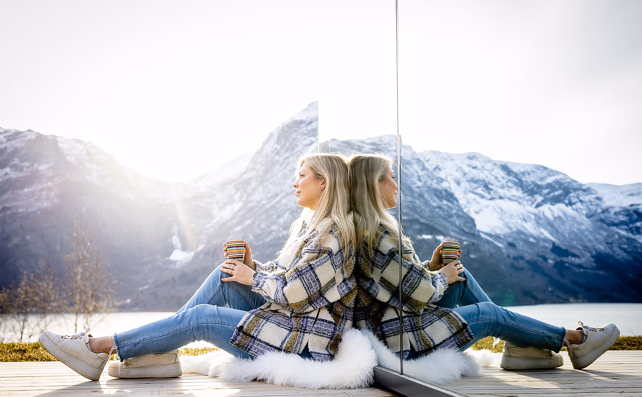 A woman sitting in front of the The Fjord Mirror in Nes Gard in Luster