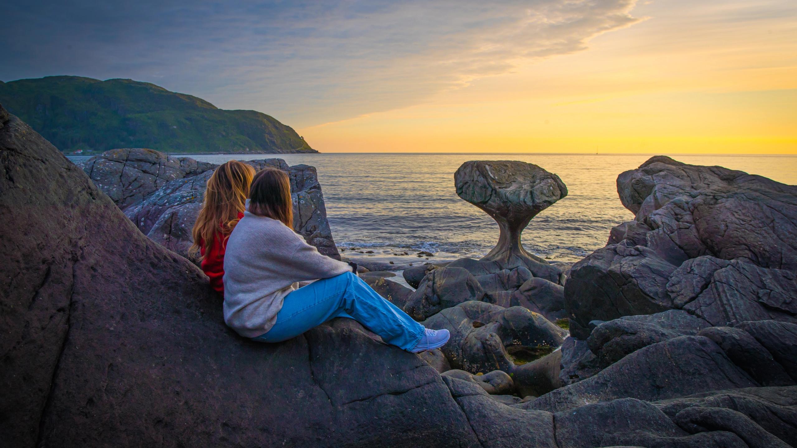 Two tourists by the Kannesteinen rock formation outside Måløy