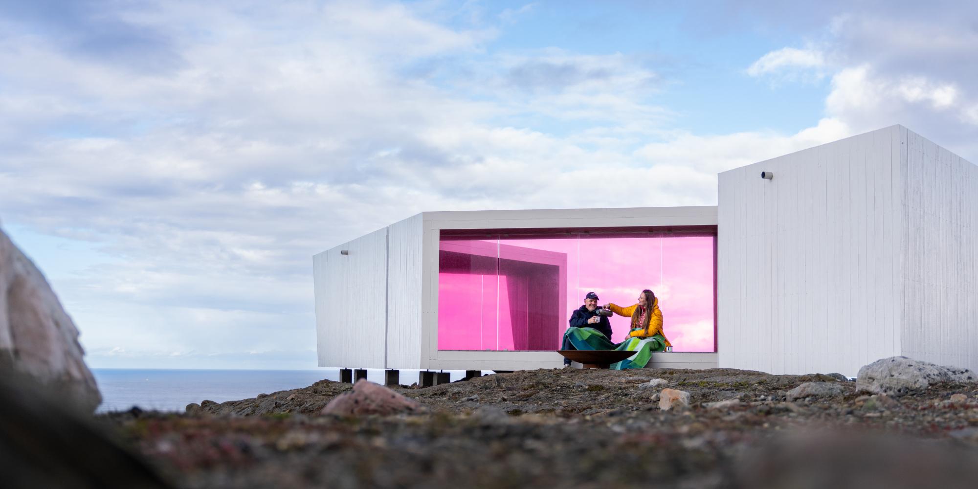 To personer sitter i Domen Viewpoint av Biotope i Varanger, Nord-Norge