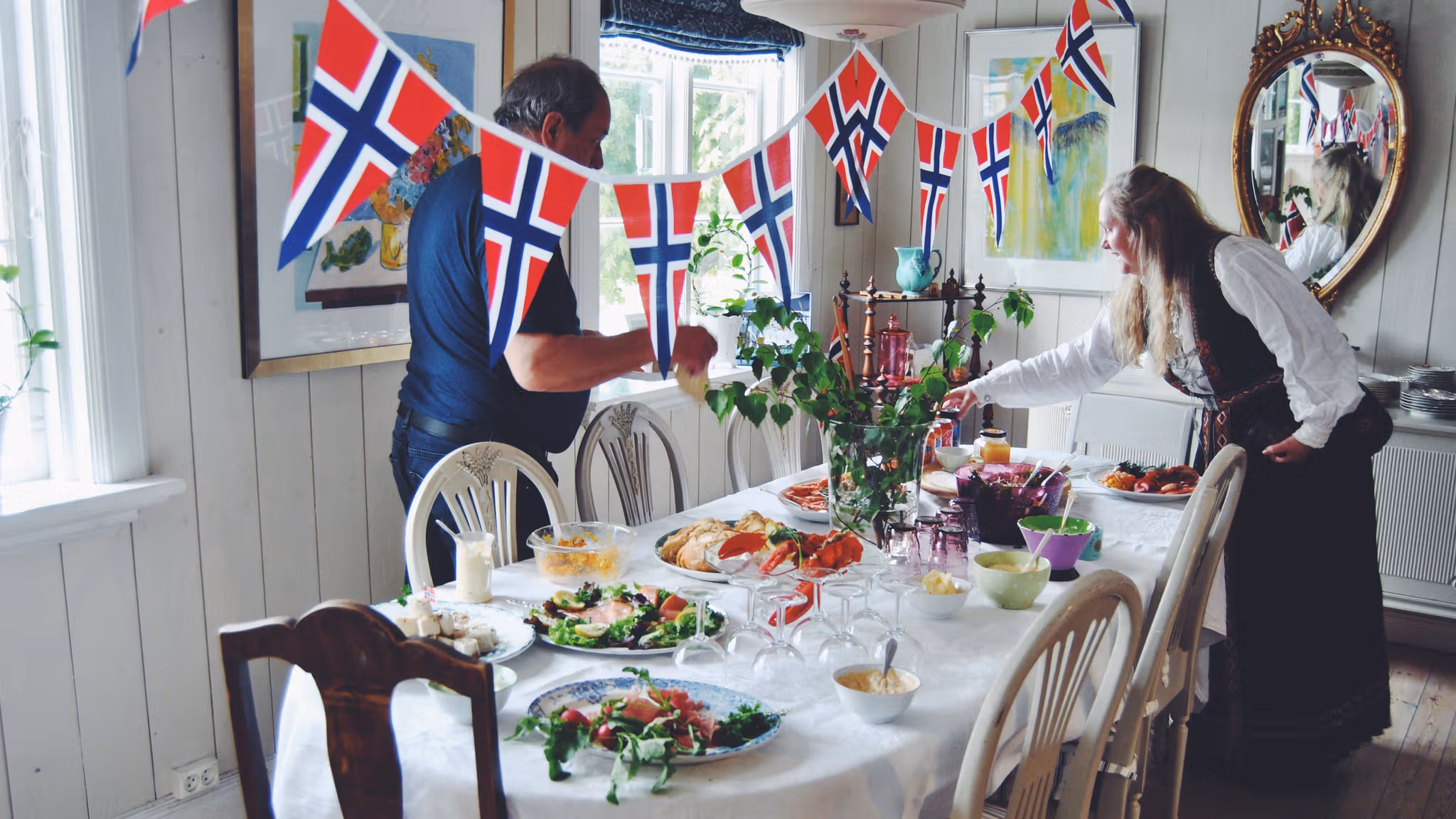 Two people are decorating the table for May 17th, Norway's national day