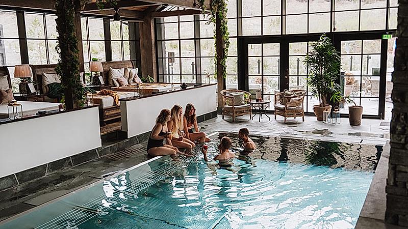 Friends enjoying the pool and spa area at Fyrí Resort, in Hemsedal