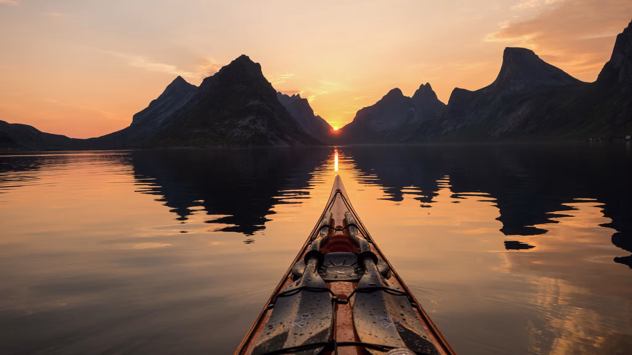 Kayaking under the midnight sun in Reinefjorden in Lofoten, Northern Norway