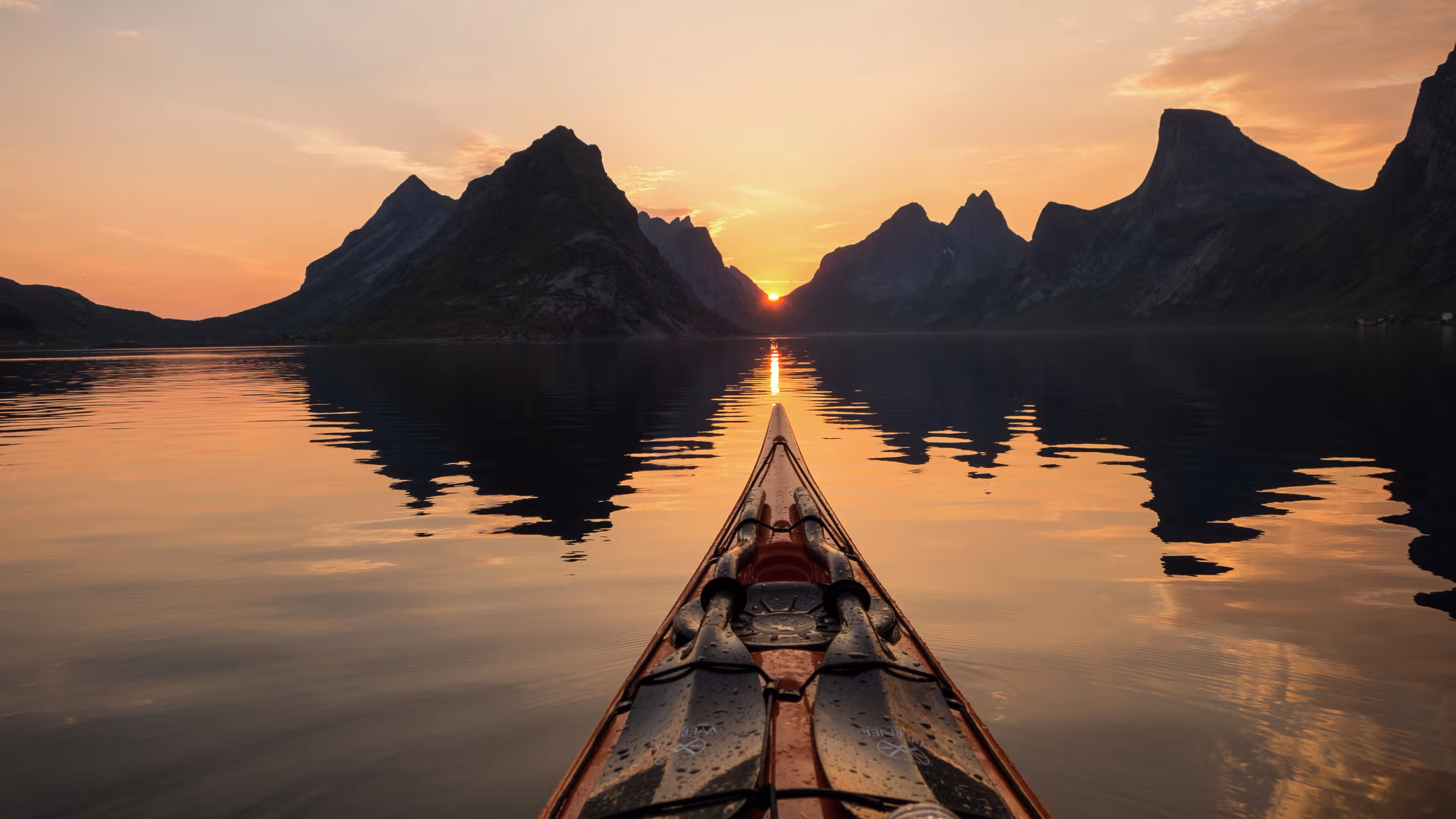 Kayaking under the midnight sun in Reinefjorden in Lofoten, Northern Norway