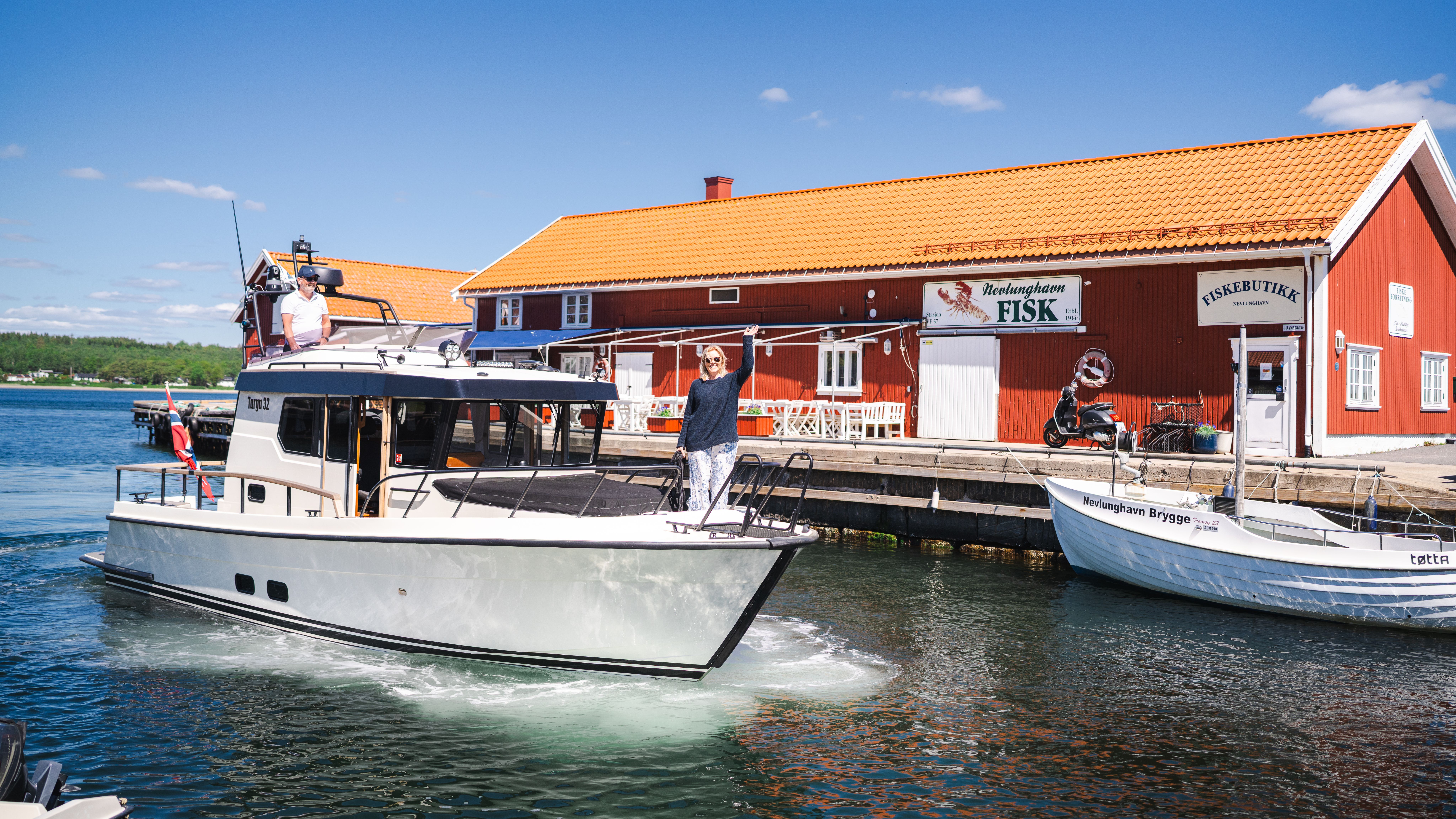 People arriving at a fishing dock by boat.