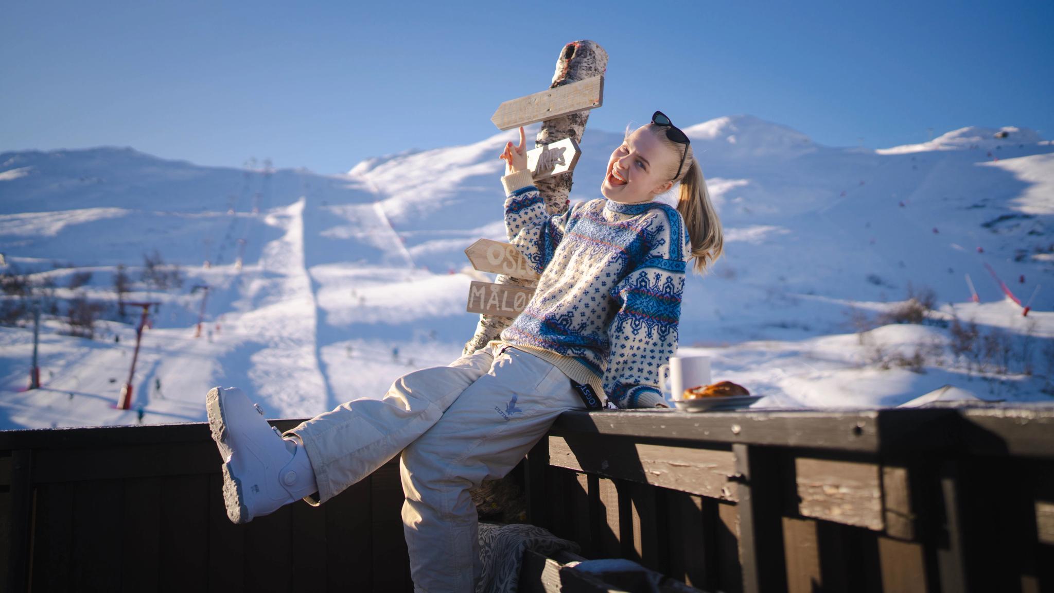 En jente som nyter solen utenfor Fjellkafeen i skibakkene i Hemsedal