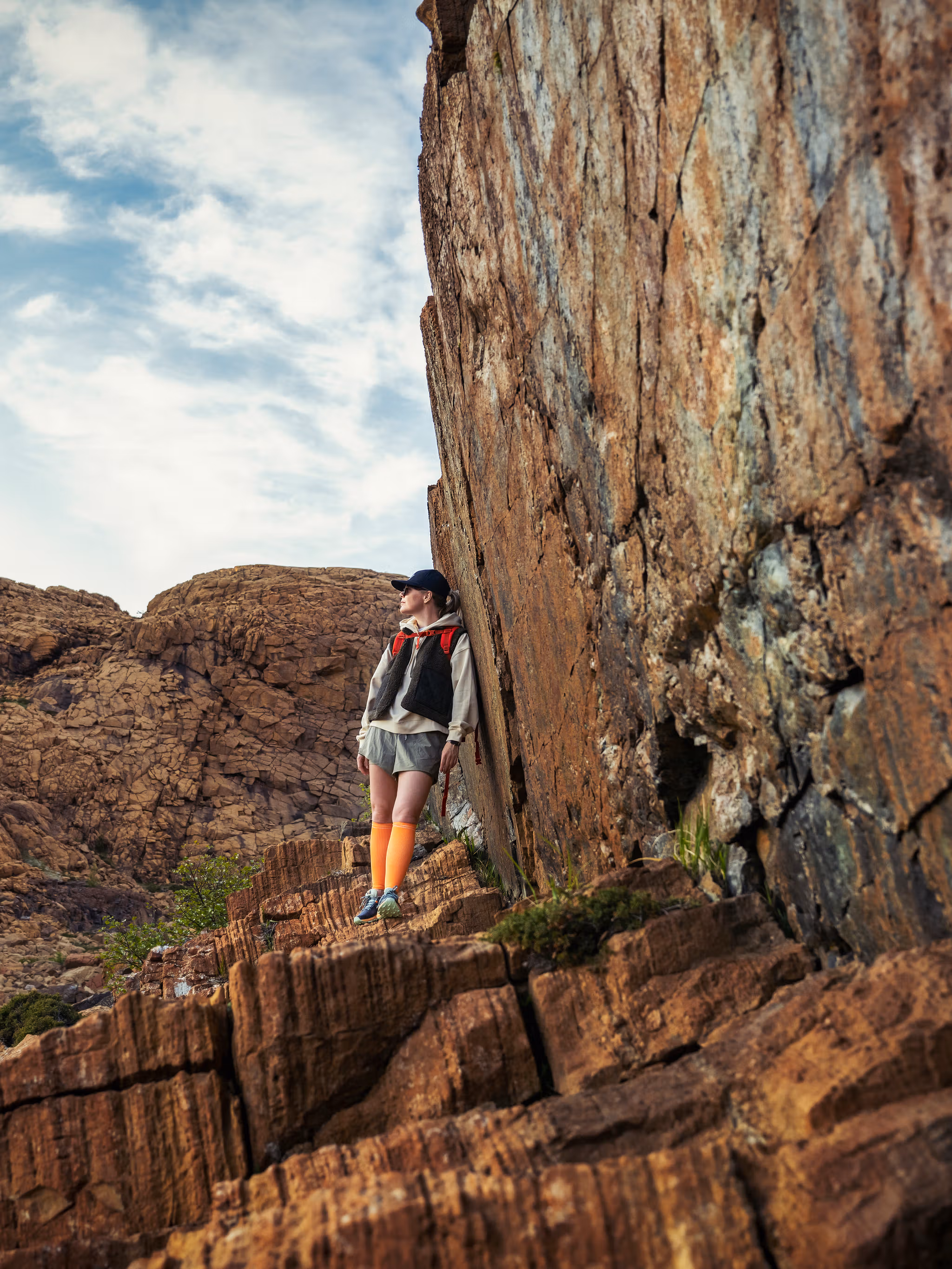 Woman hiking between the red rocks at Leka island in Trøndelag