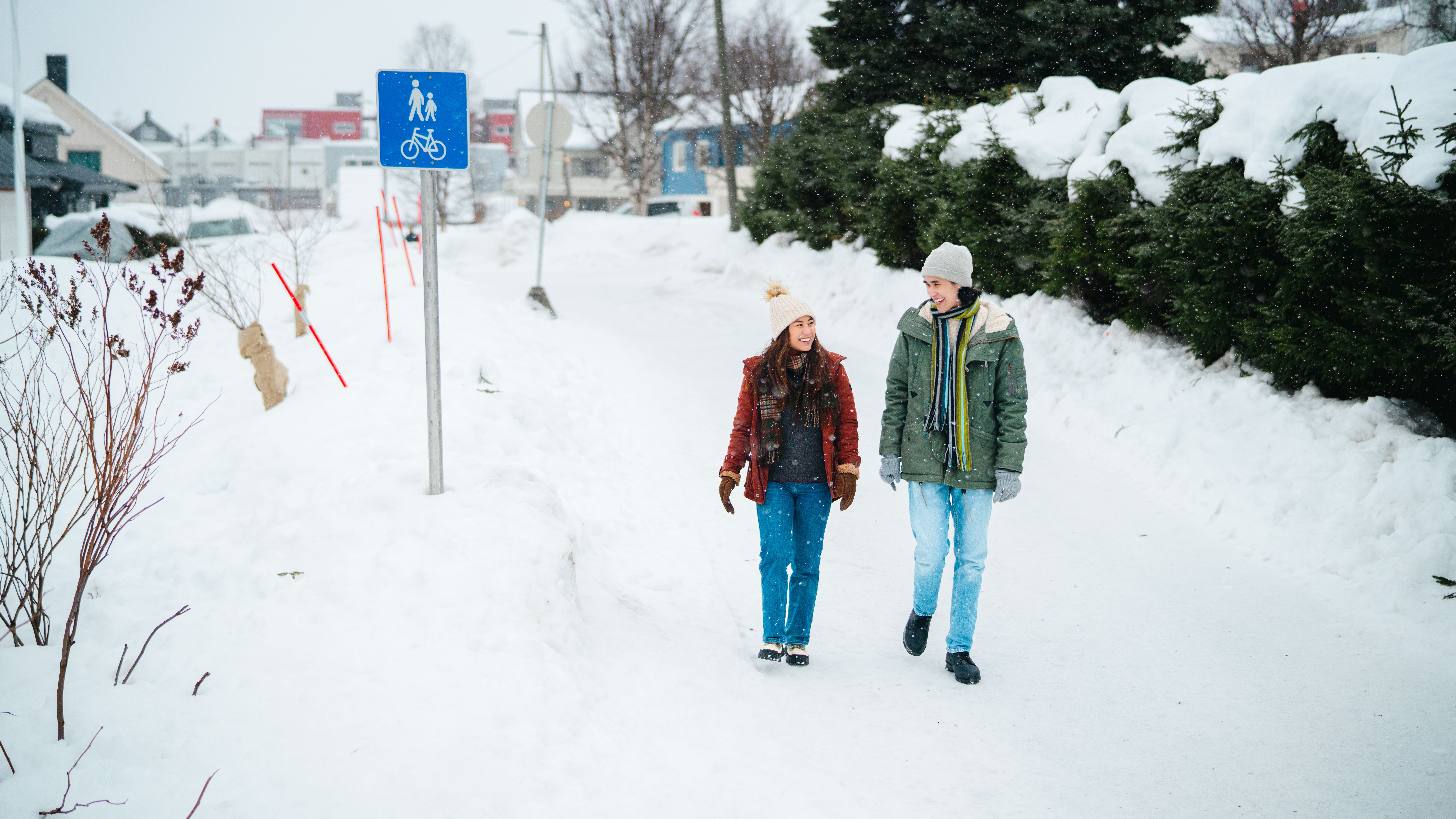 Two tourists walking on a pedestrian path in Tromsø