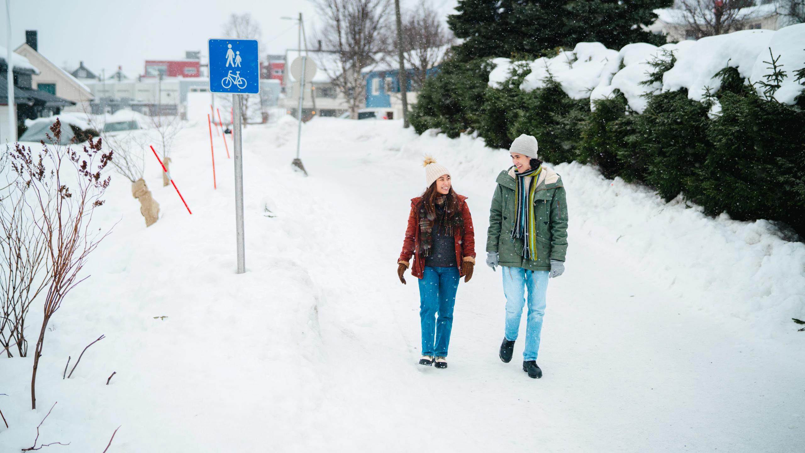 Two tourists walking on a pedestrian path in Tromsø