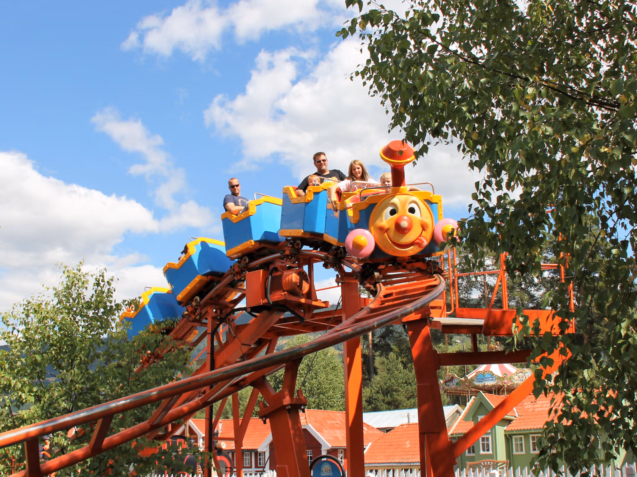 A family riding a carousel in Lilleputthammer amusement park, Norway