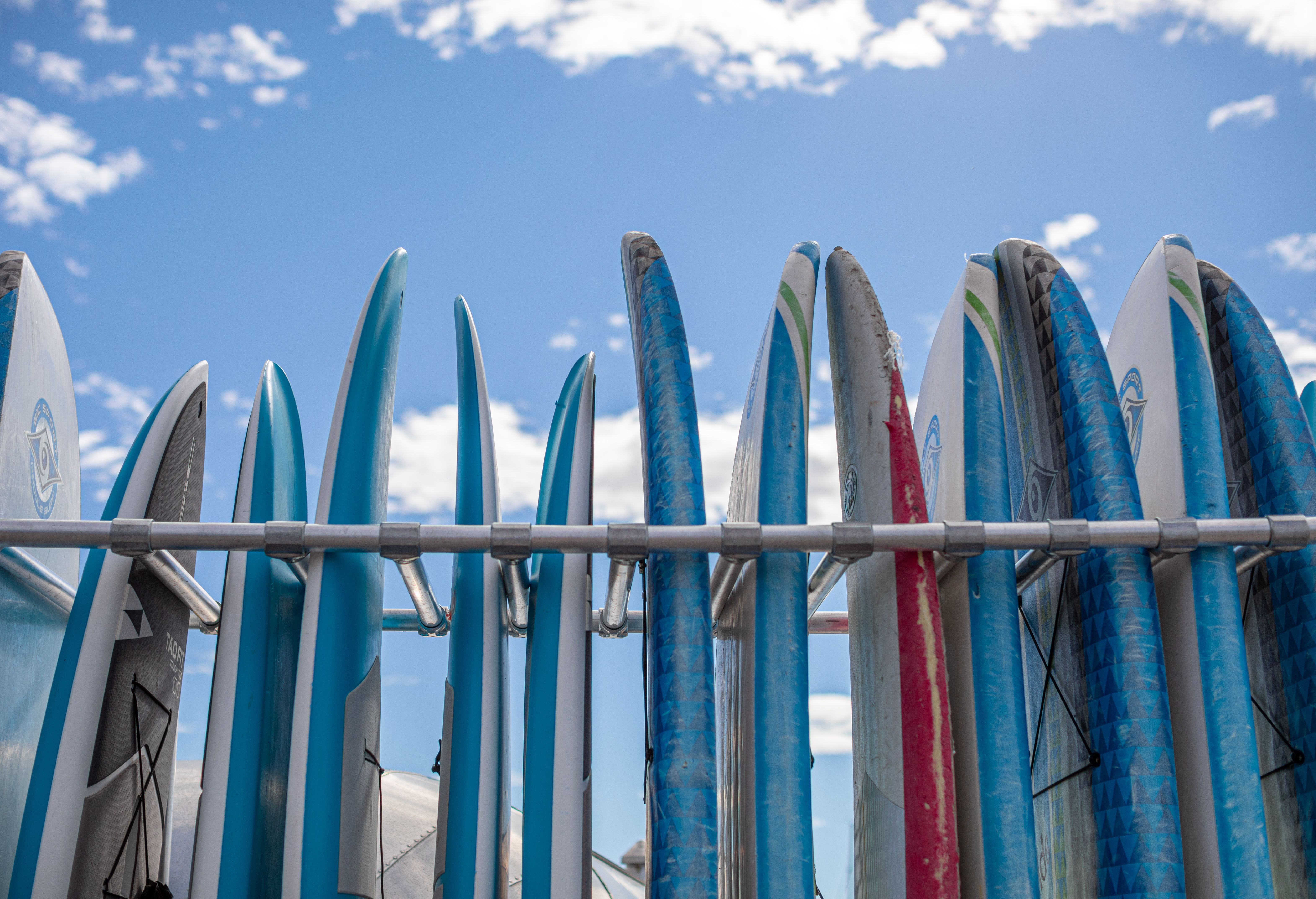 Thirteen SUP-boards stands in a rack