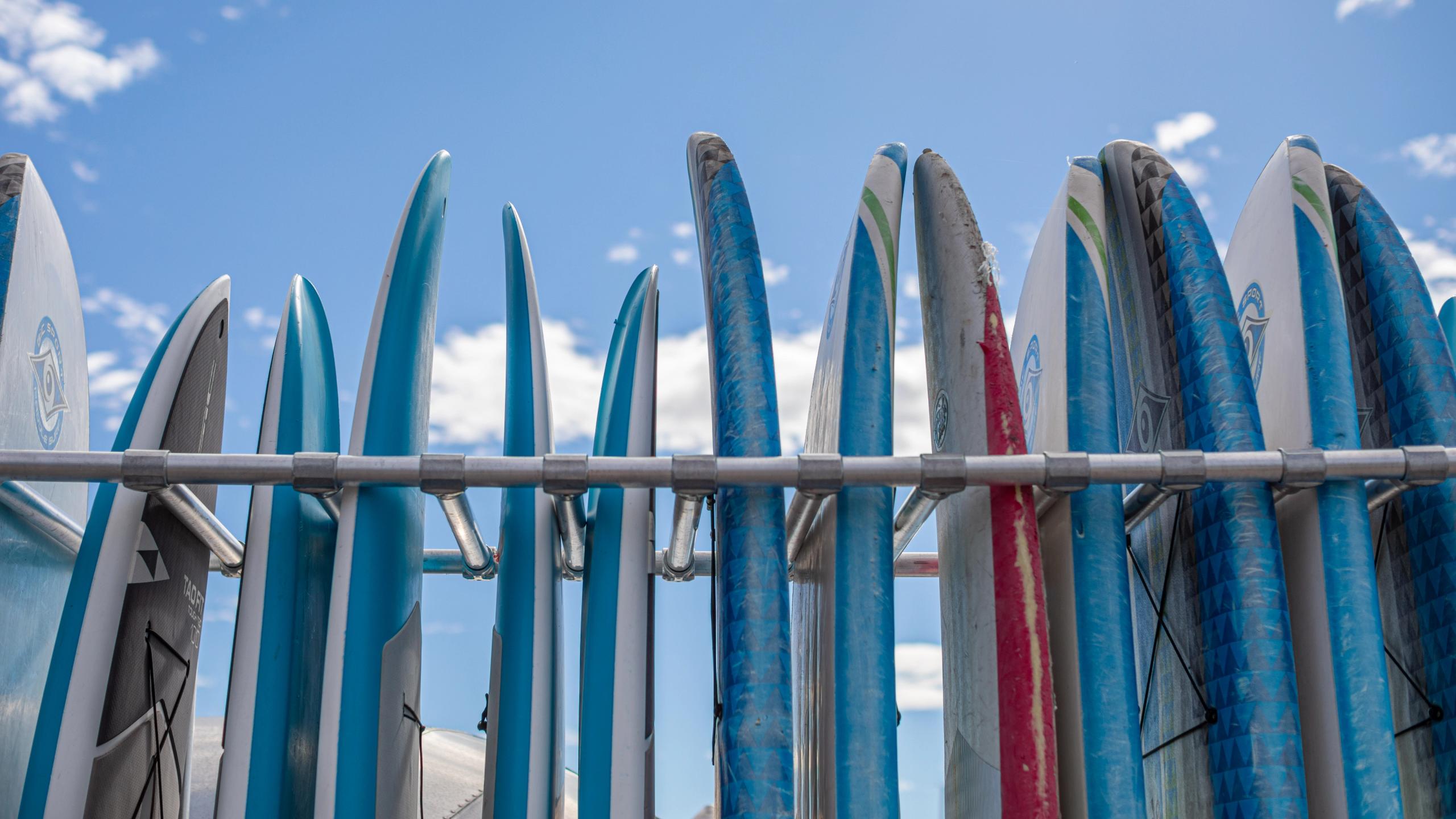 Thirteen SUP-boards stands in a rack