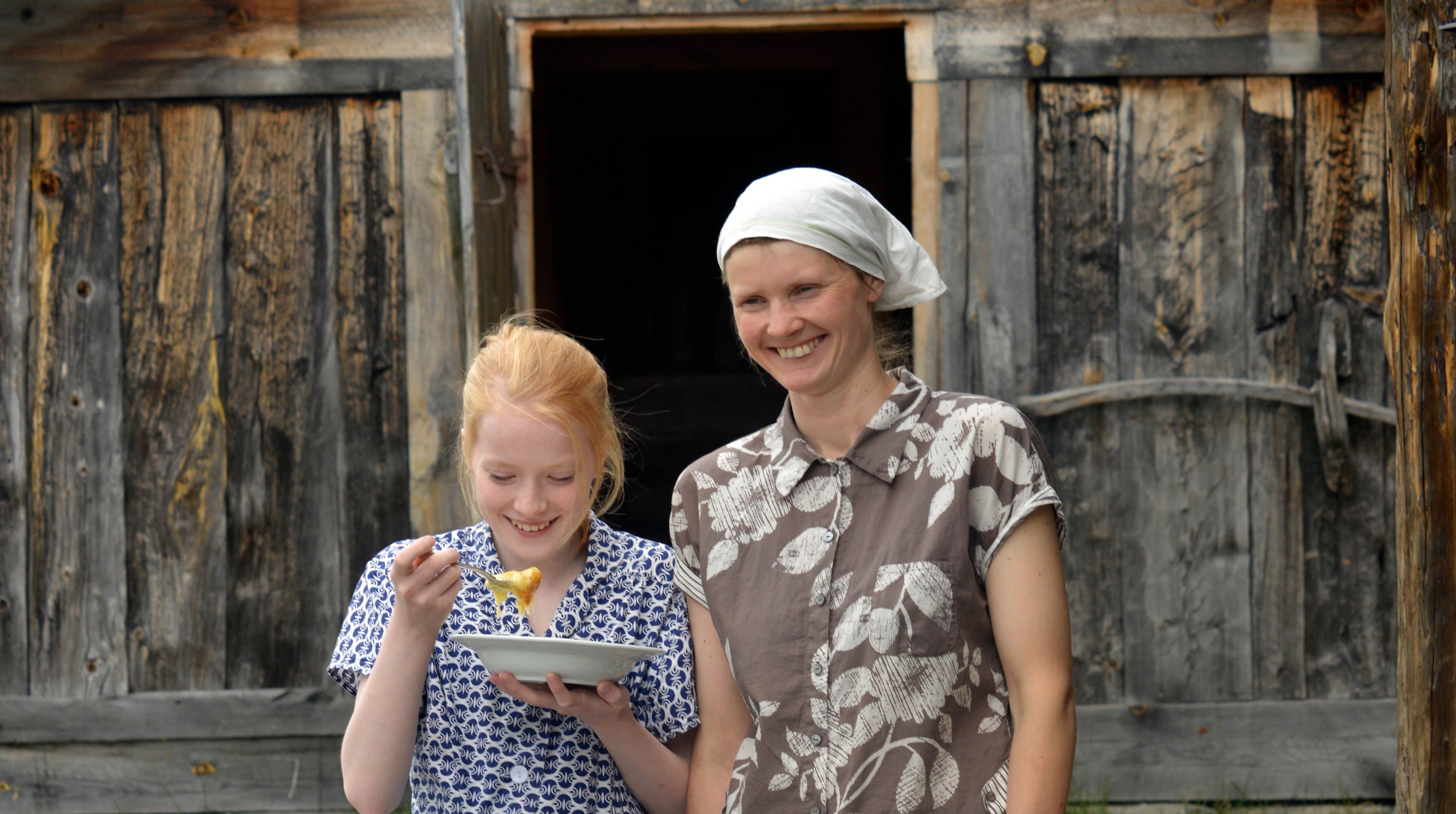 Two women eating traditional porridge made with sour cream in Rjukan in Telemark, Eastern Norway