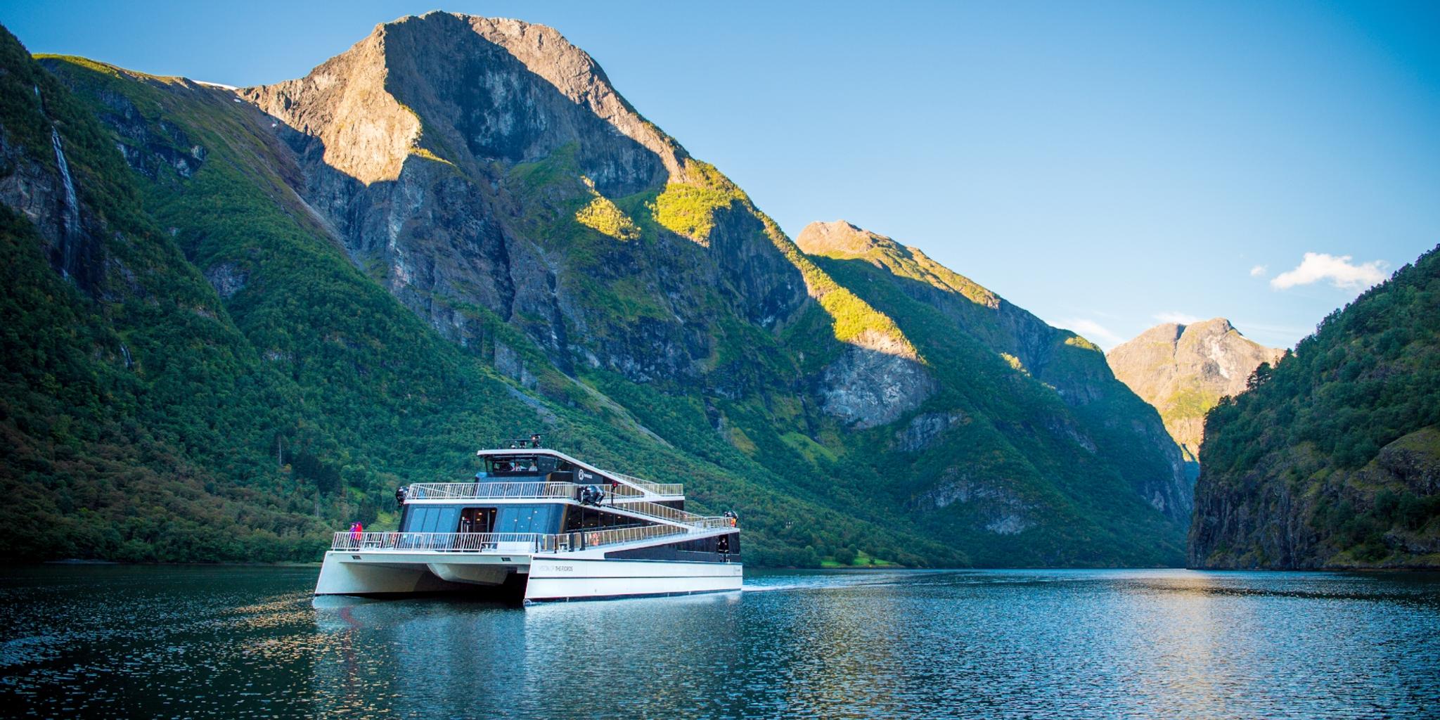 The hybrid electric vessel Vision of the Fjords cruising the Aurlandsfjorden fjord surrounded by mountains