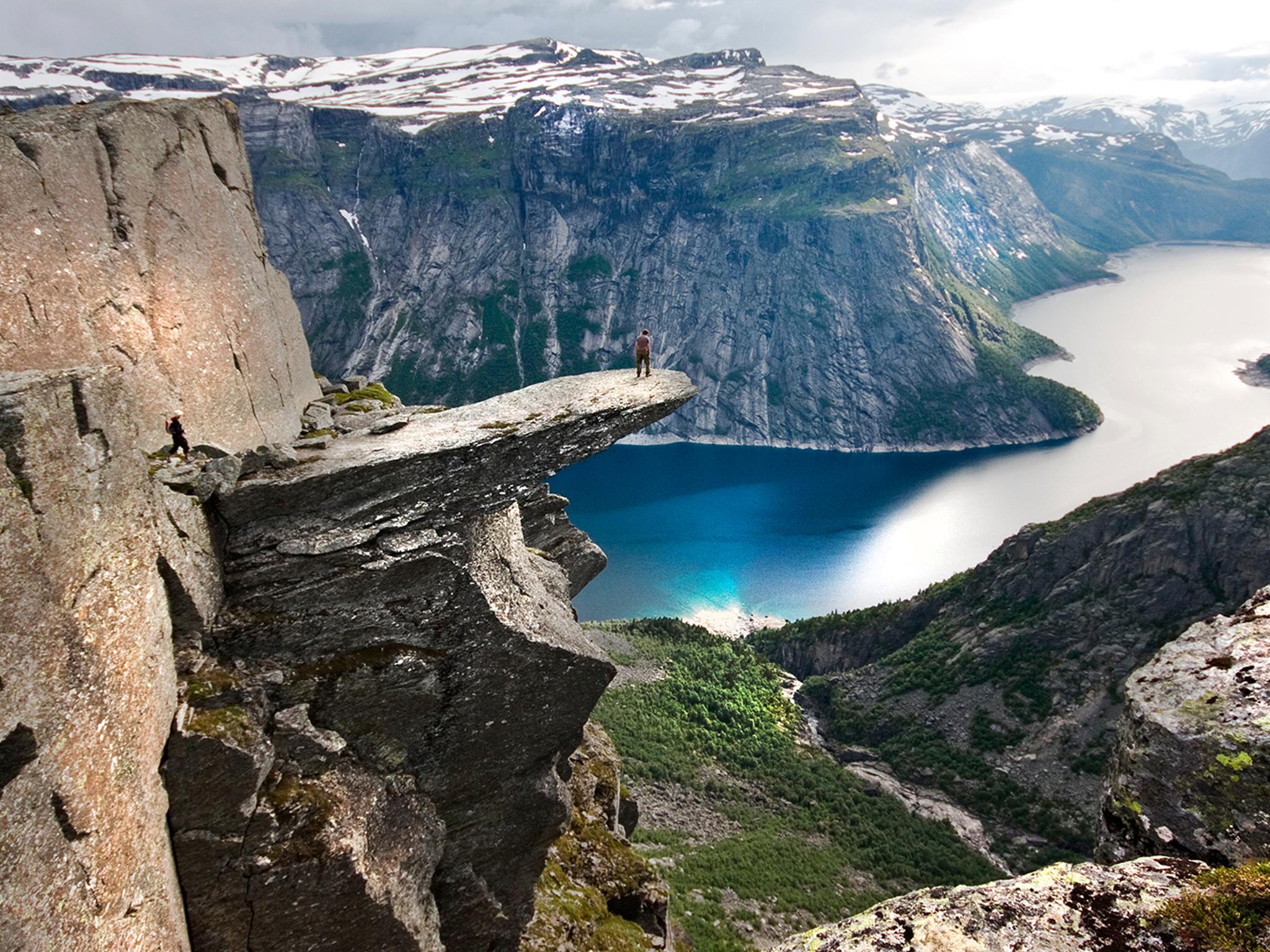 Escursionista sull’altopiano di Trolltunga sopra il lago Ringedalsvatnet nella regione di Hardangerfjord, Norvegia dei fiordi