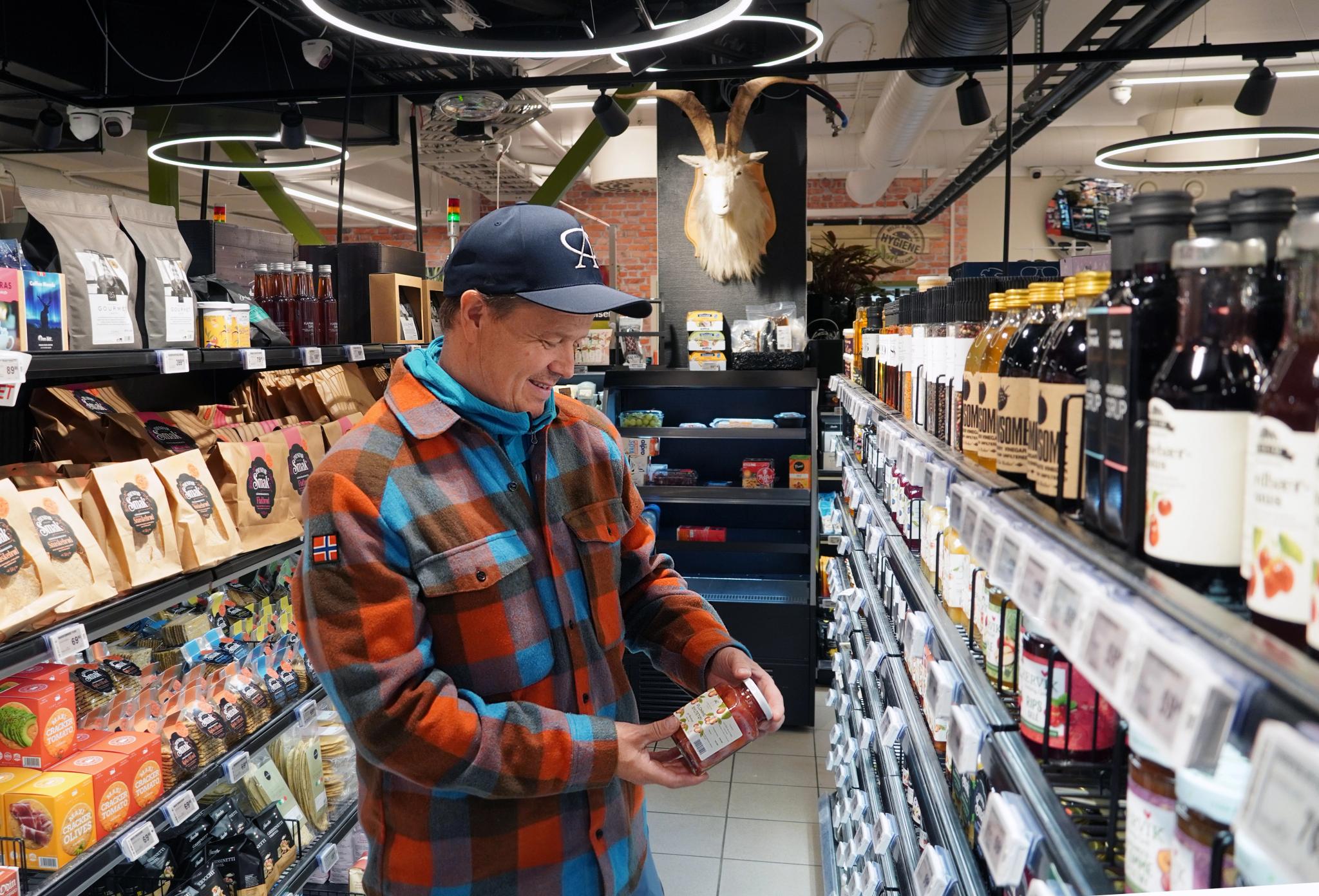 A man buying local food at Åkrafjordtunet local food store in Åkrafjorden