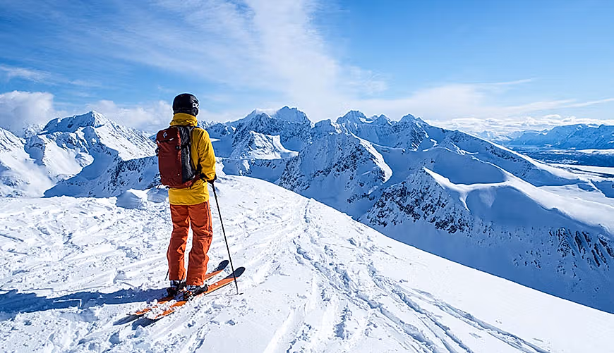 Skikjører på toppen av fjell i Lyngsalpene