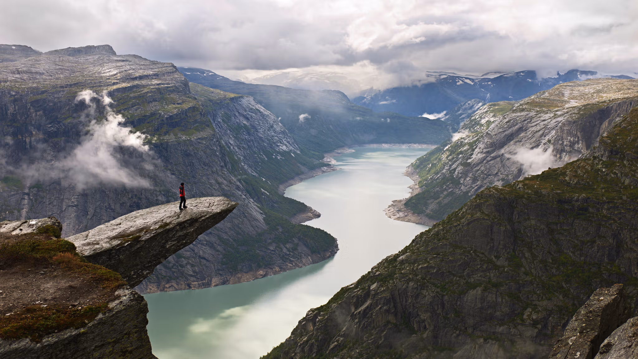 A person on the mountain plateau Trolltunga above Lake Ringedalsvatnet in the Hardangerfjord region, Fjord Norway