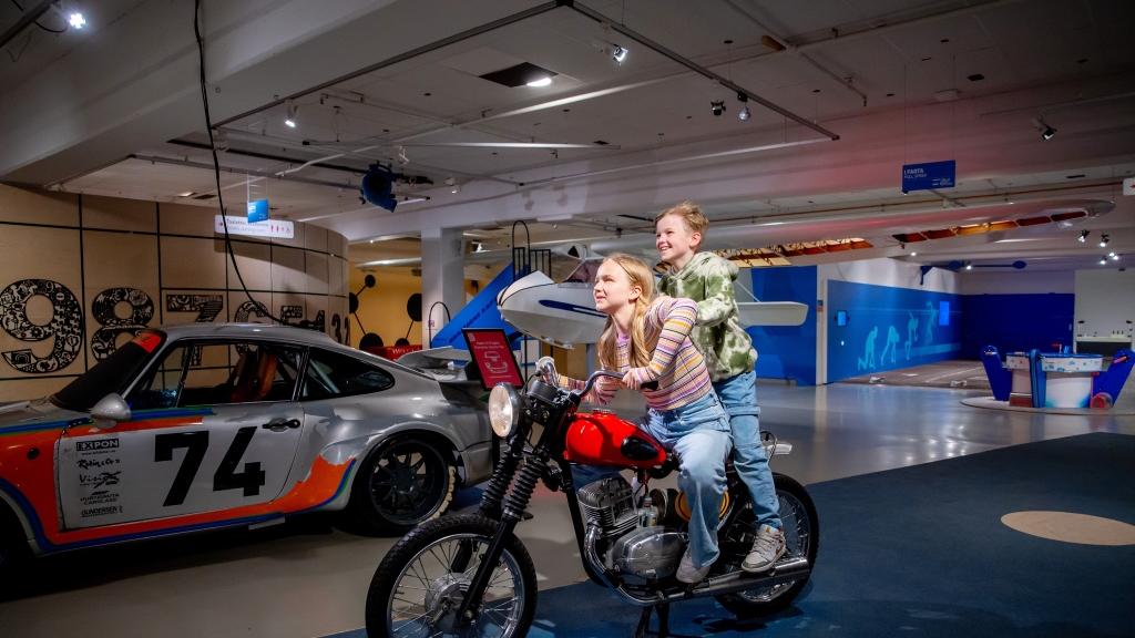 To barn på en motorsykkel i et museum.
