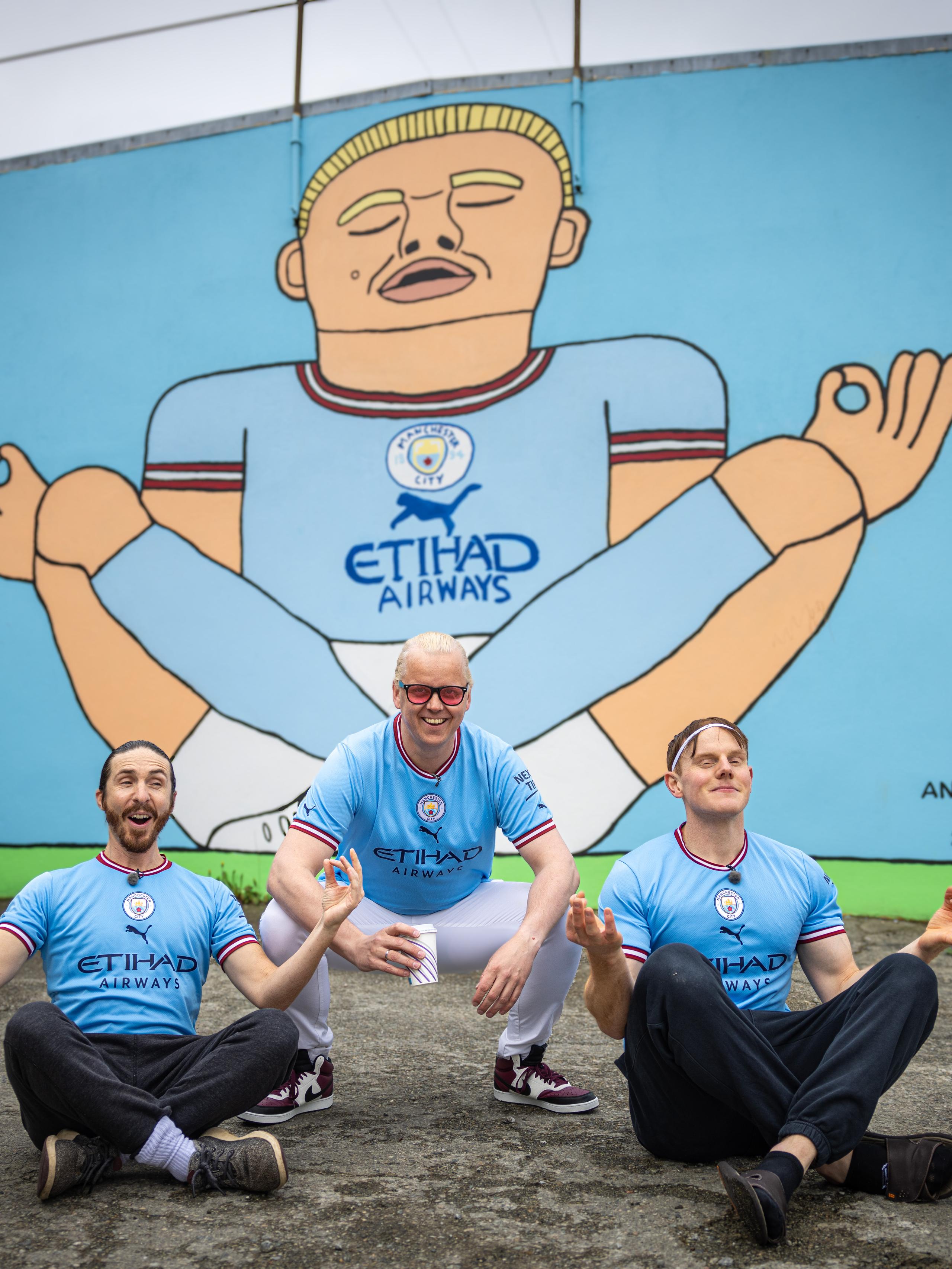 Three men in front of the Erling Braut Haaland street art by Anette Moi in Bryne, Fjord Norway