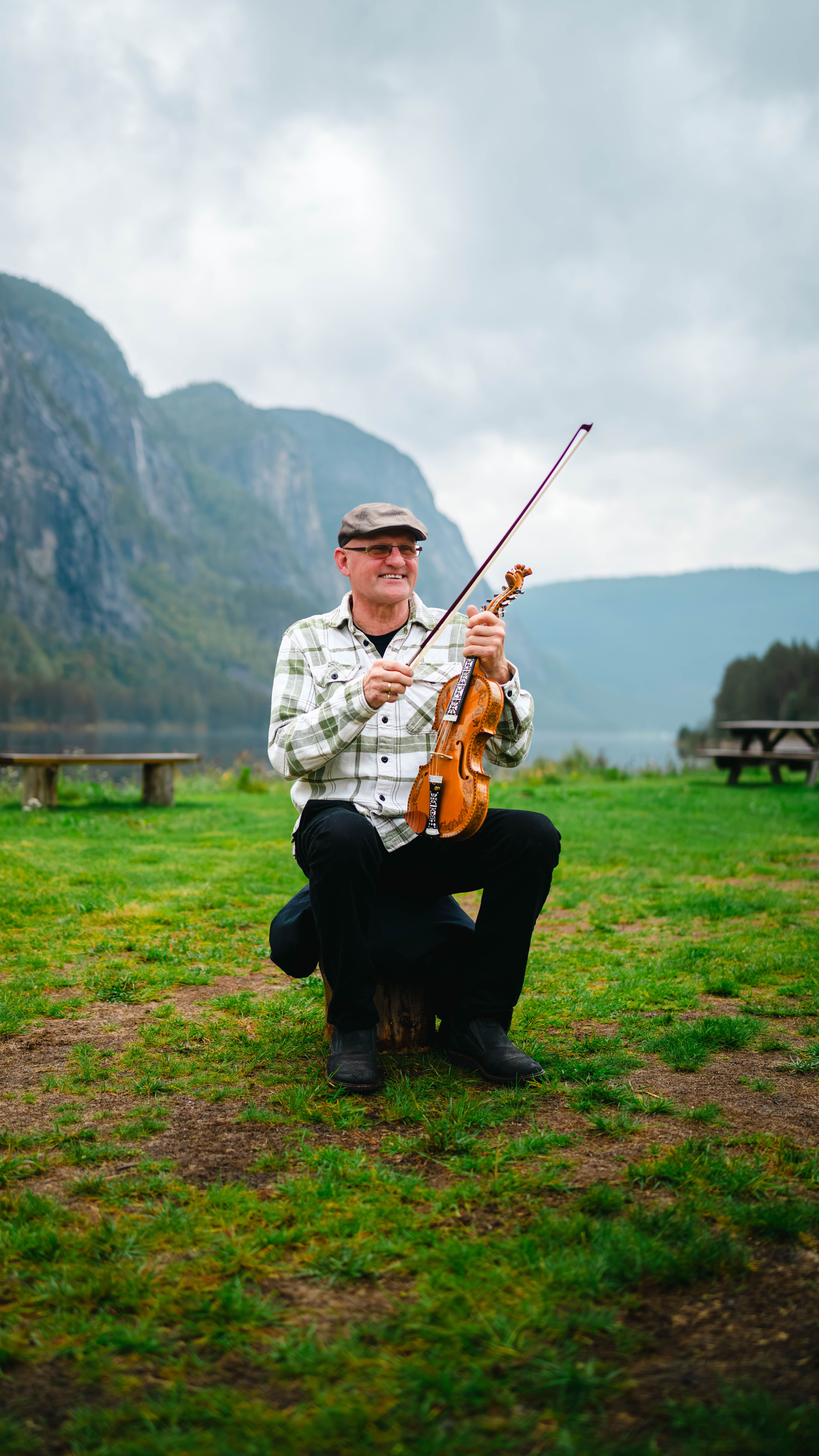 Marton Laksesvela with his Hardingfele (a unique Norwegian fiddle) with a stunning mountain backdrop in Setesdal