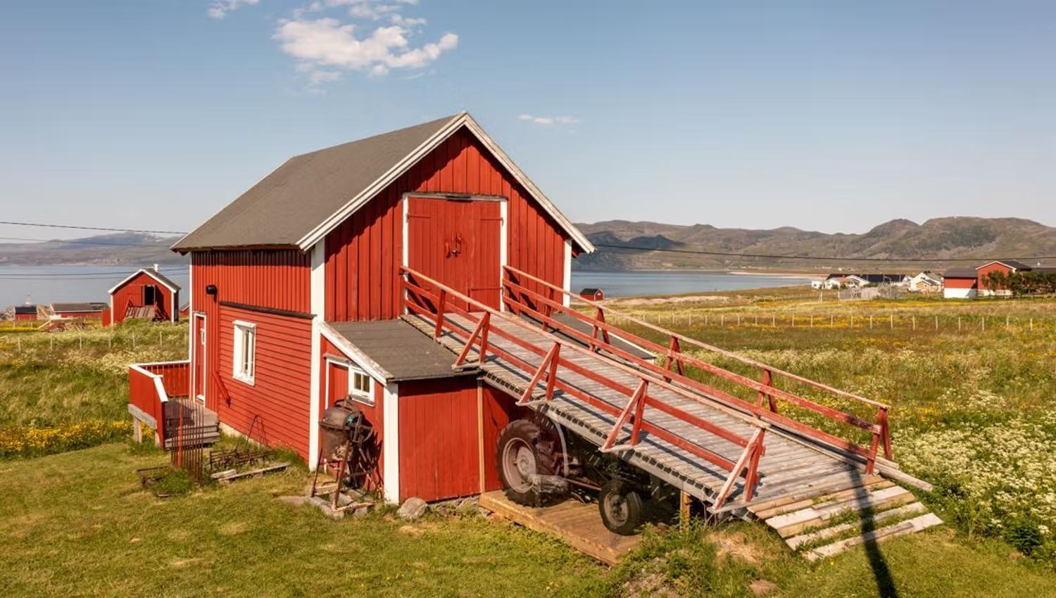A red barn and a tractor at Kokelv Coastal Sámi Museum 