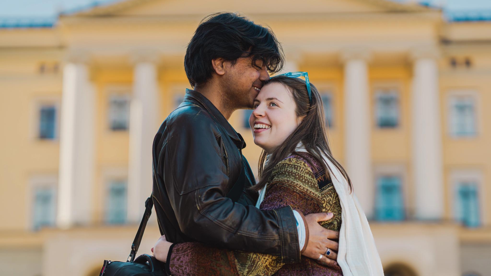 A couple in front of the Royal Palace in Oslo