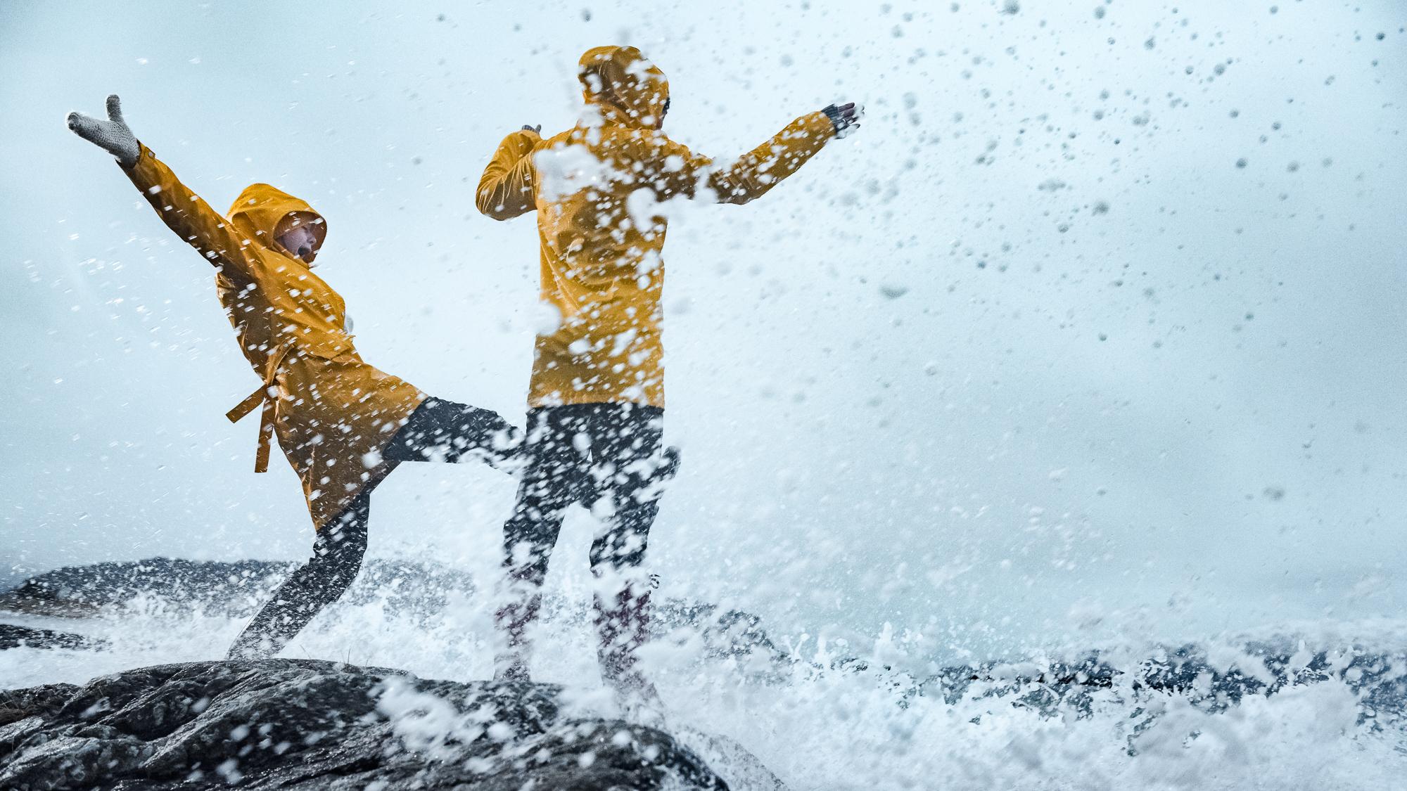 Two people playing in the storm in Kalvåg, Fjord Norway