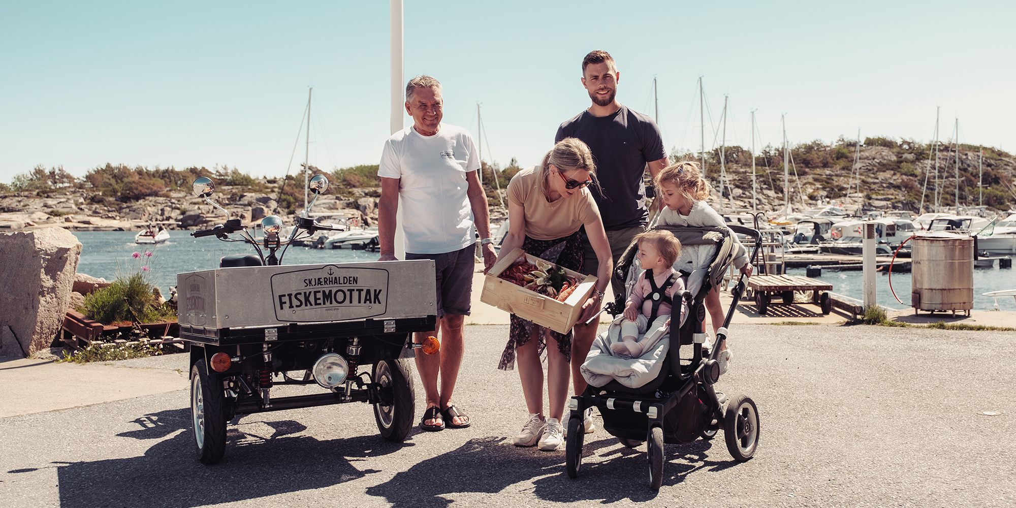 En familie kjøper en skalldyrkasse på Skjærhalden fiskemottak på Hvaler
