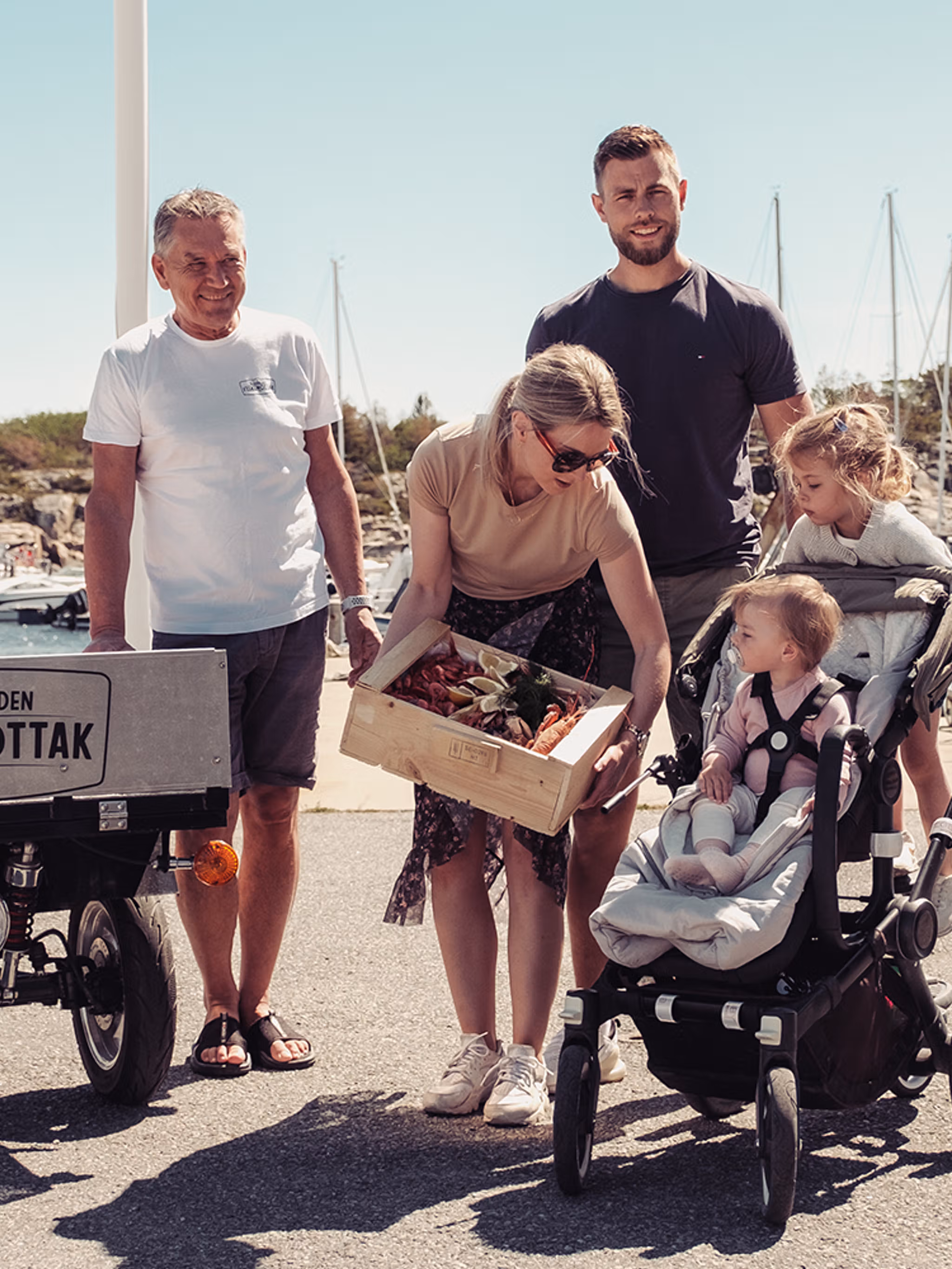 En familie kjøper en skalldyrkasse på Skjærhalden fiskemottak på Hvaler
