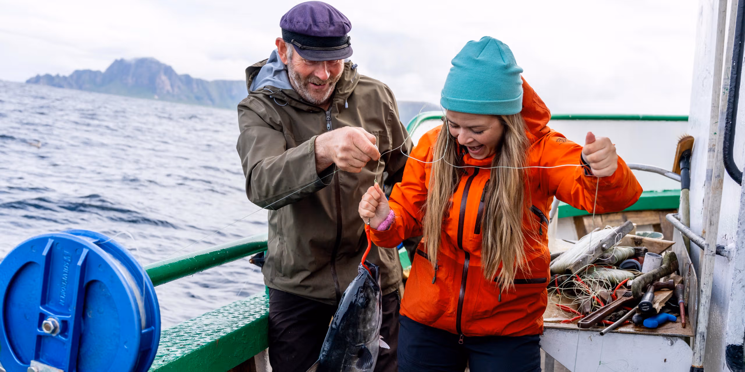 En mann og en kvinne har akkurat fangen en fisk på sjøen.