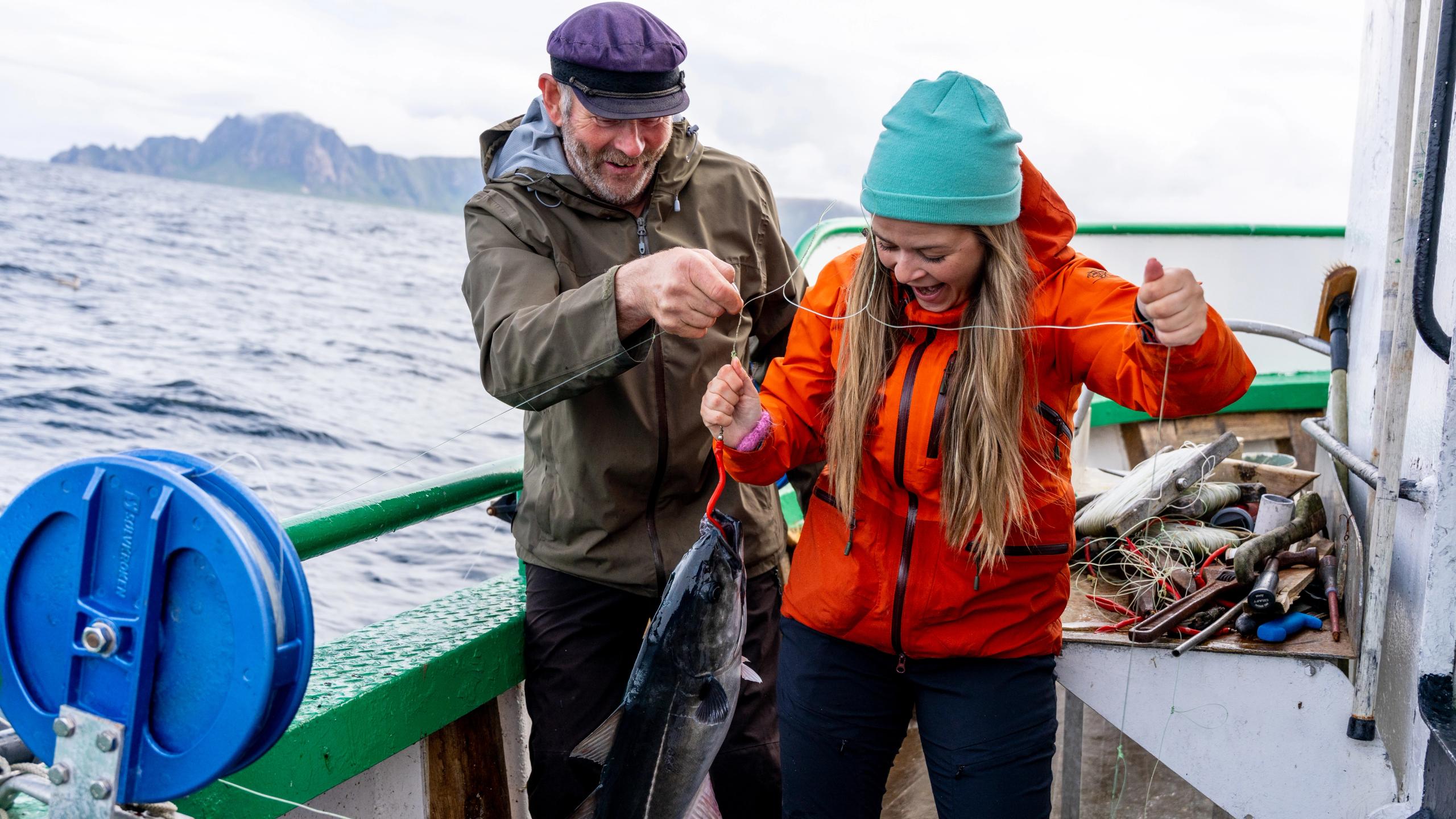 En mann og en kvinne har akkurat fangen en fisk på sjøen.