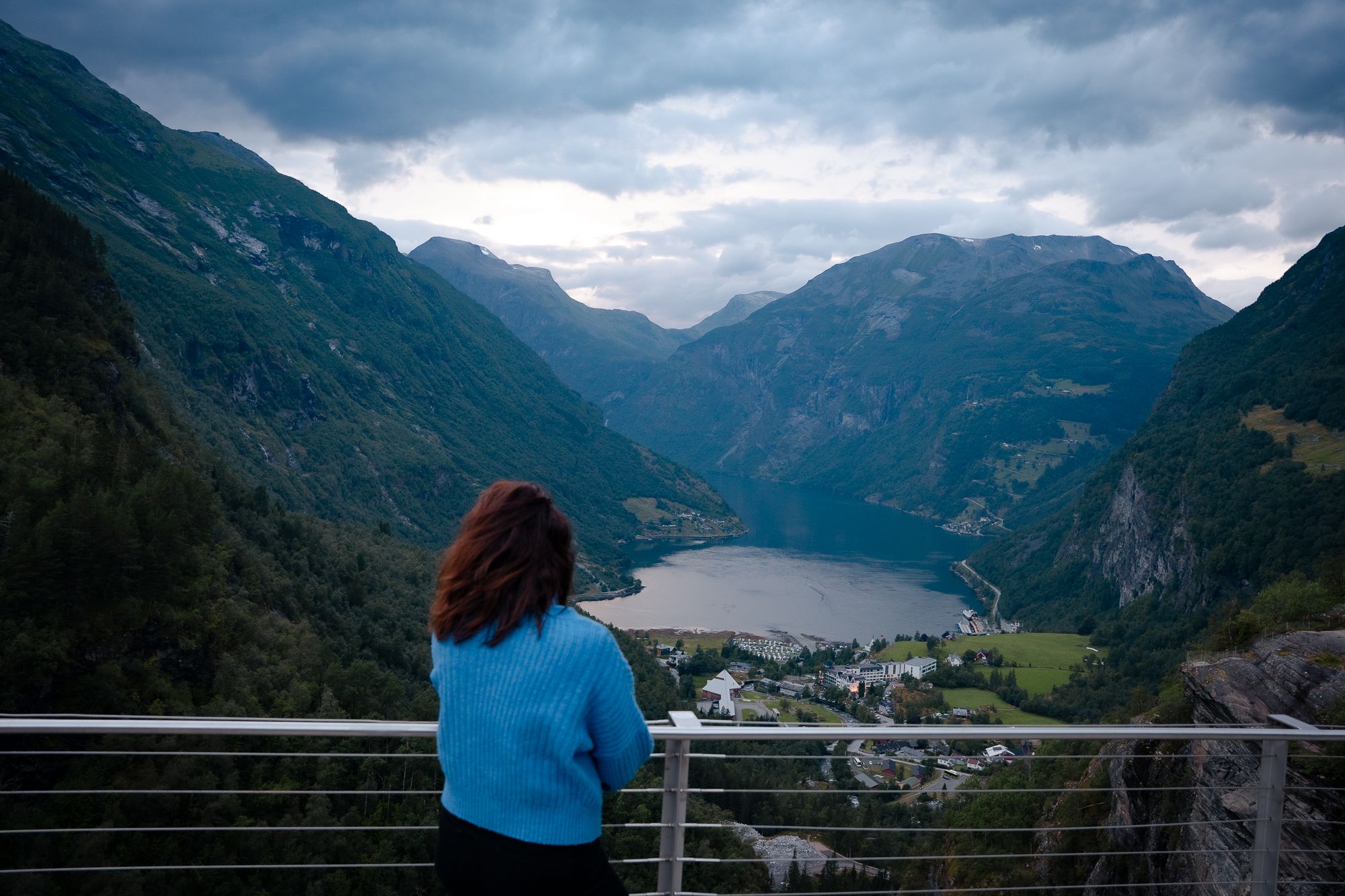A woman enjoying the view of Geiranger from Flydalsjuvet