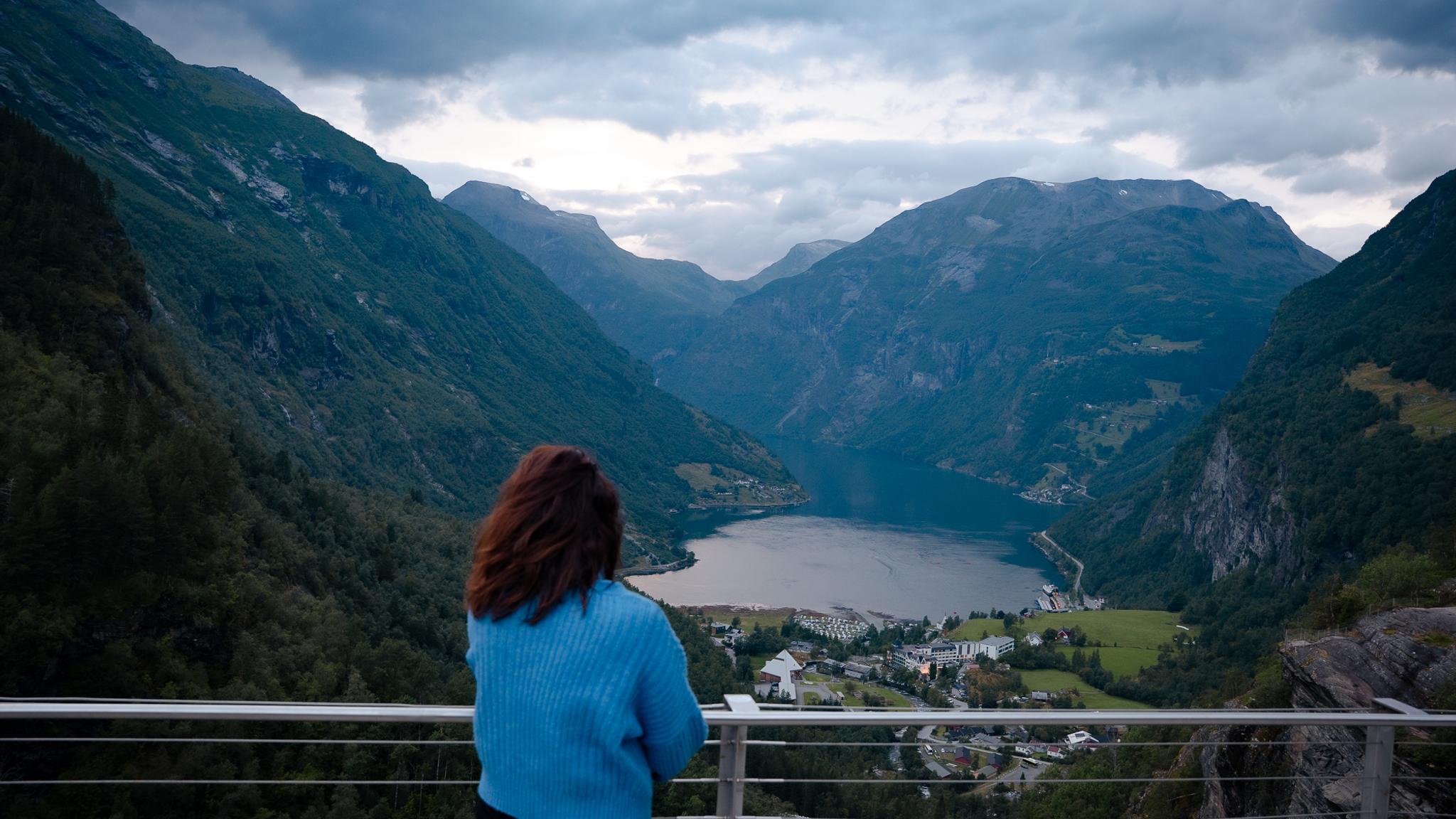 A woman enjoying the view of Geiranger from Flydalsjuvet
