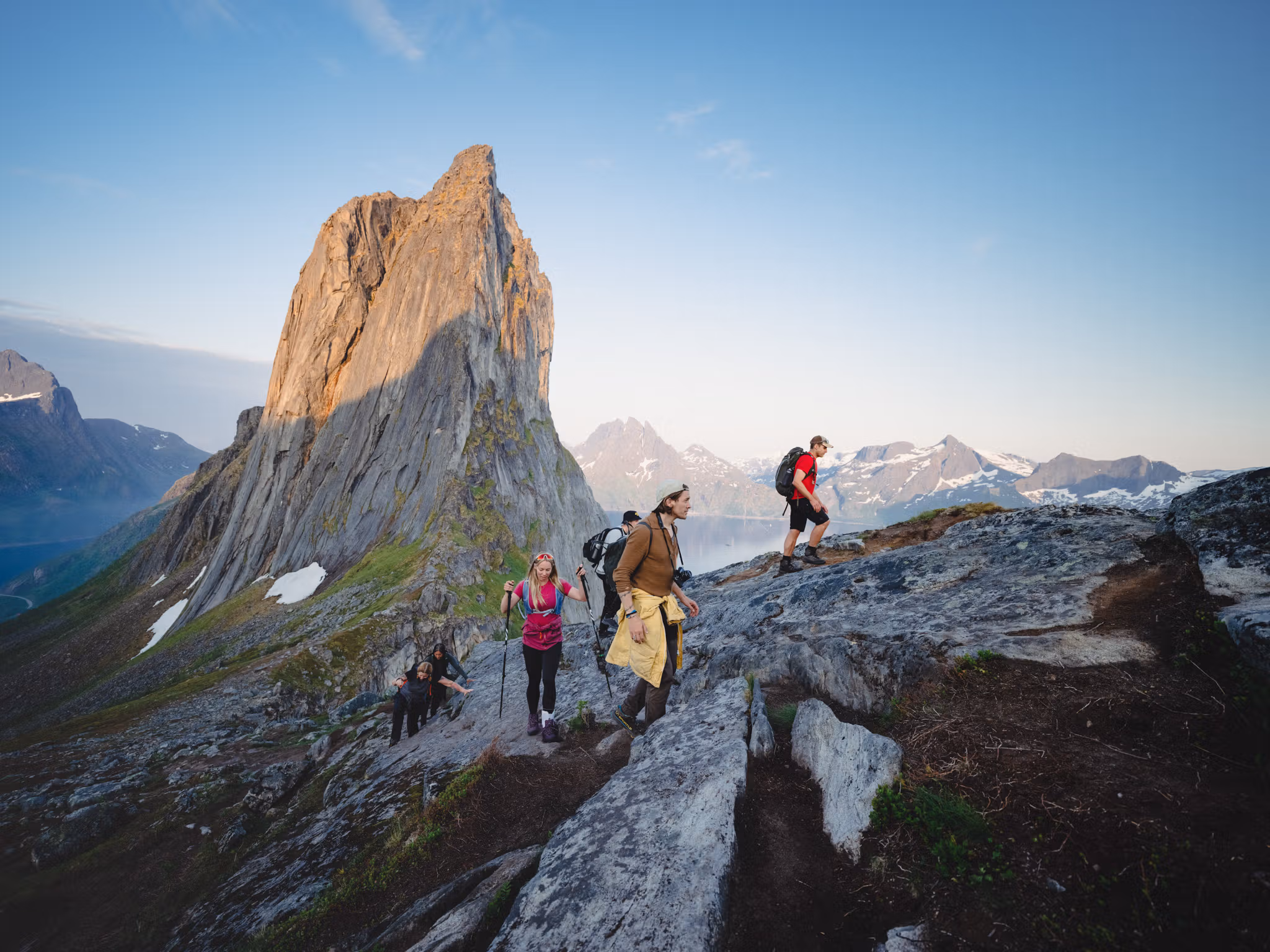 People hiking up a steep mountain with beautiful views.