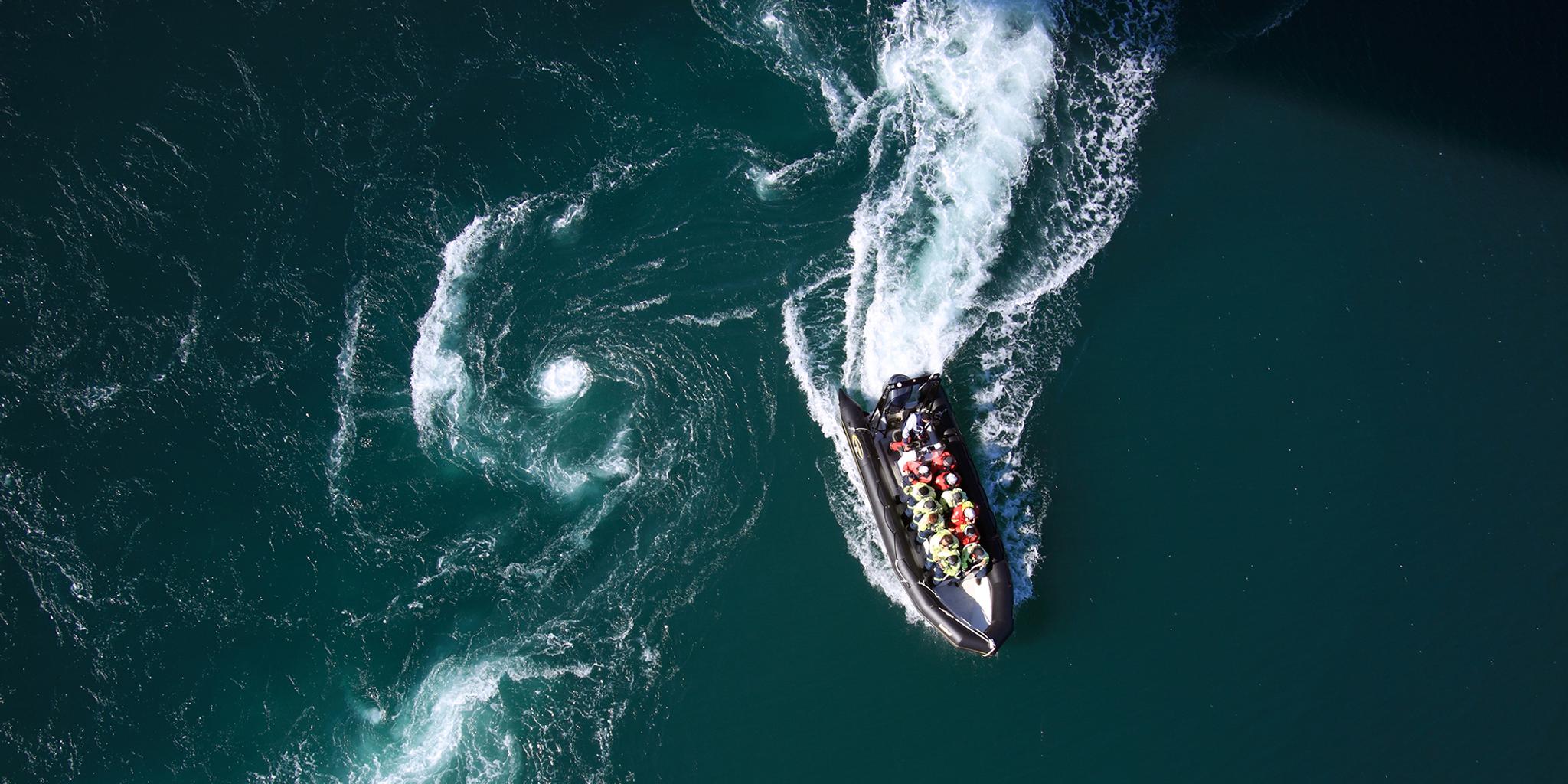 Un bateau semi-rigide rempli de passagers, vu du ciel, navigant sur le Saltstraumen à Bodø, en Norvège du Nord