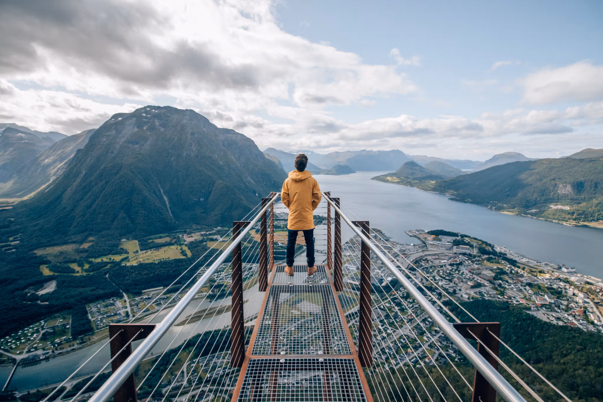 En person ser ut över fjordlandskapet vid utsiktsplatsen Rampestreken i Åndalsnes i området Nordvest, Fjord Norge