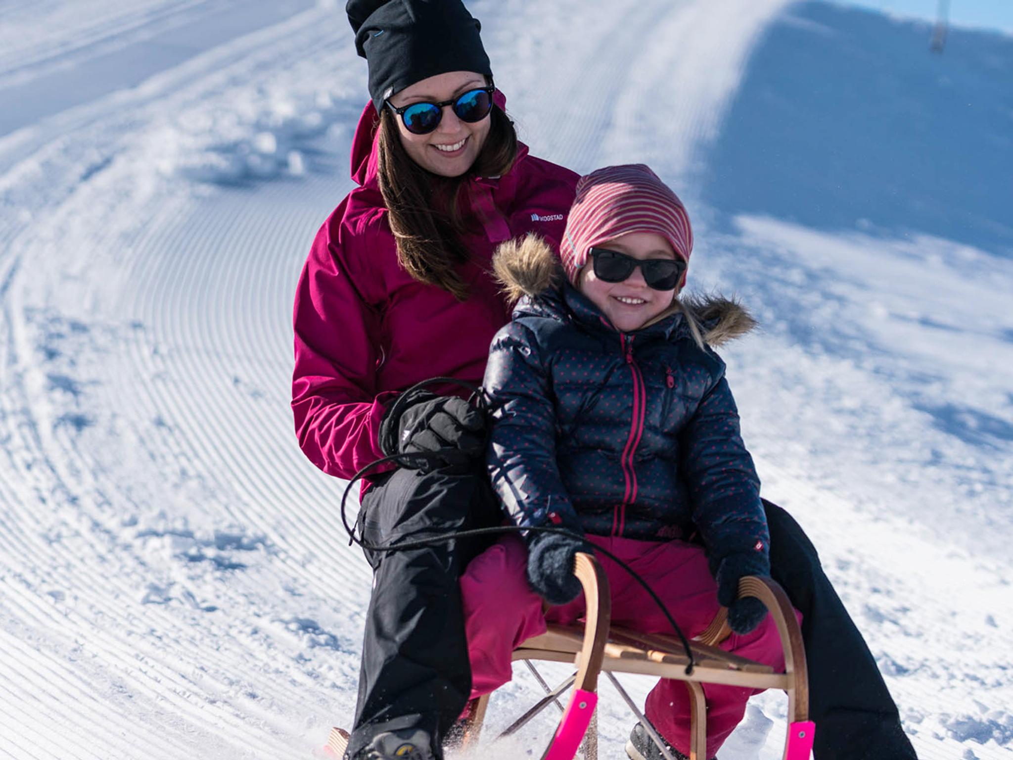 Mother and daughter tobogganing at Mount Hoven by the Loen Skylift in Loen, Fjord Norway