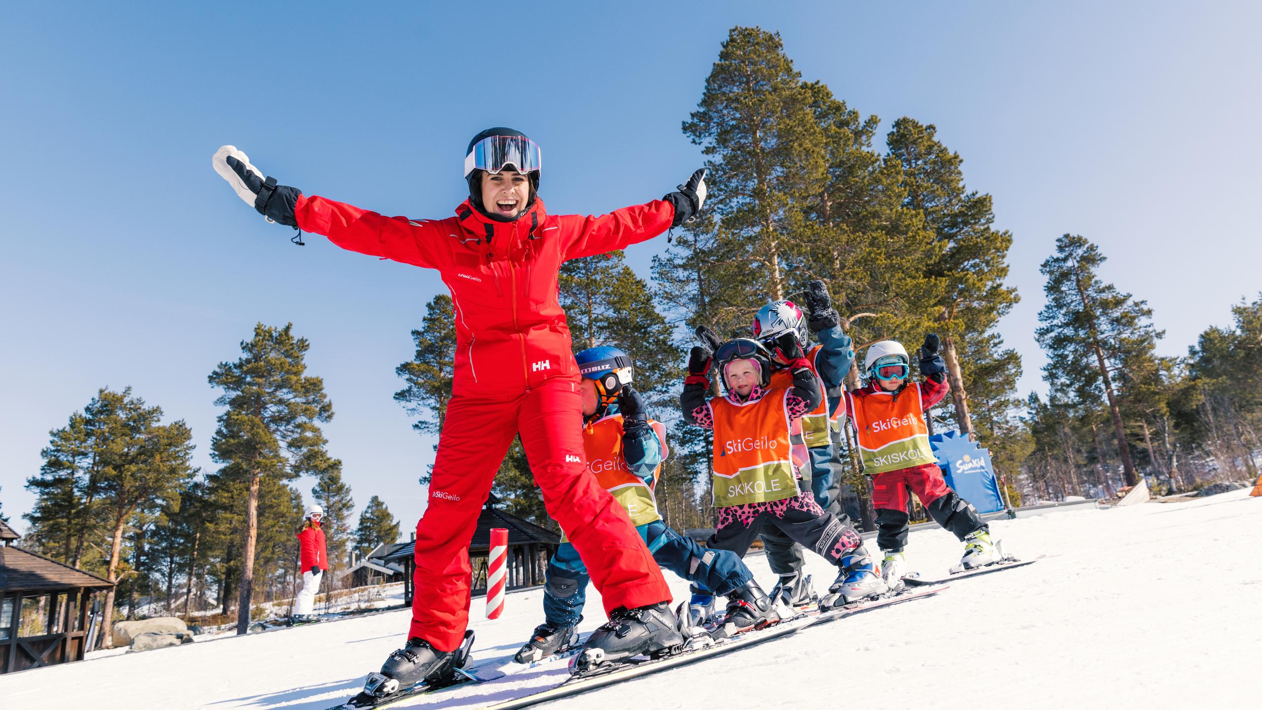 En skiinstruktør sammen med yngre personer på ski.